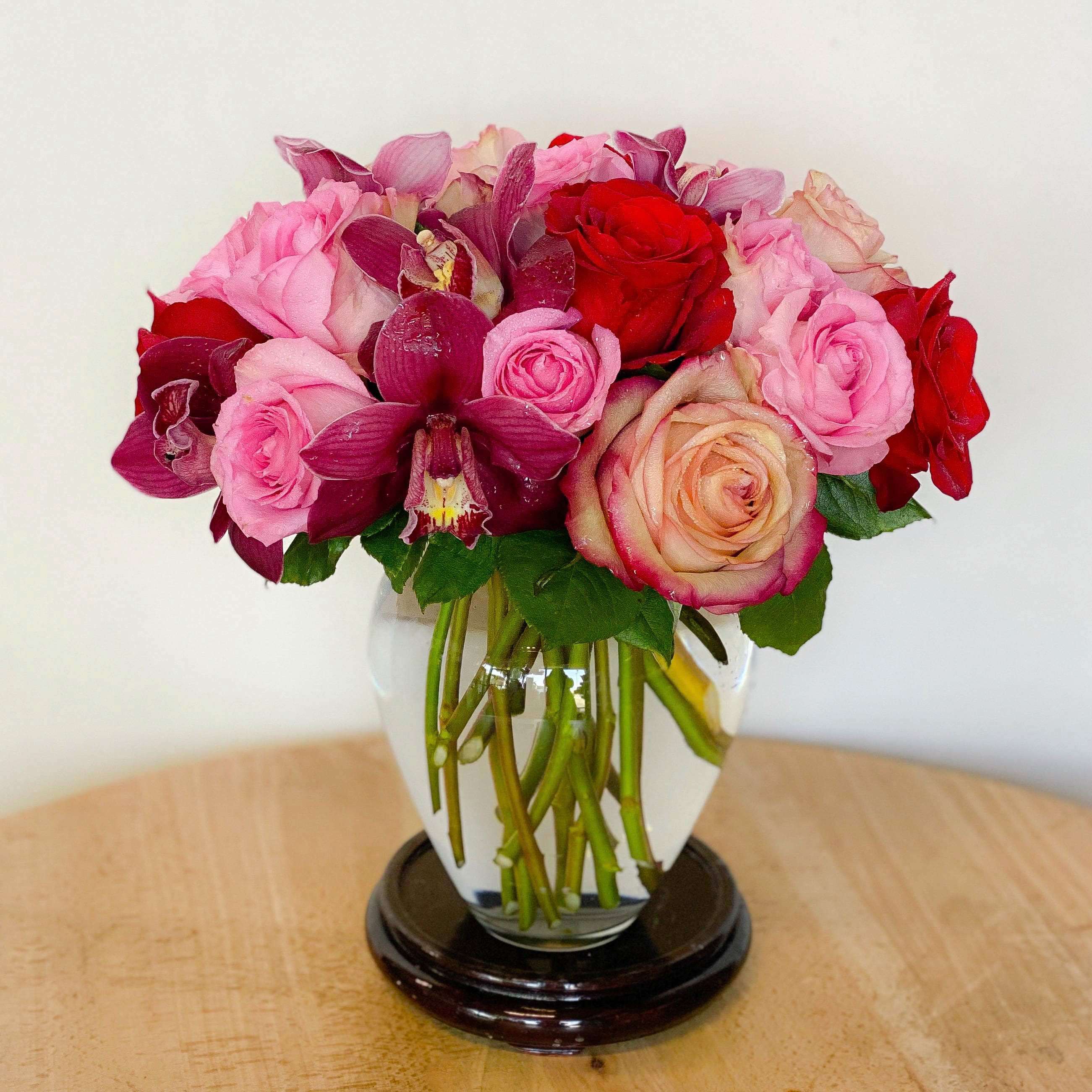 Truly Adored - The best bouquet to send to the one you truly adored! Order this arrangement of lush purple cymbidium orchids, red roses, &amp; pink roses designed in a keepsake glass gathering vase.   Approximately  12" D
