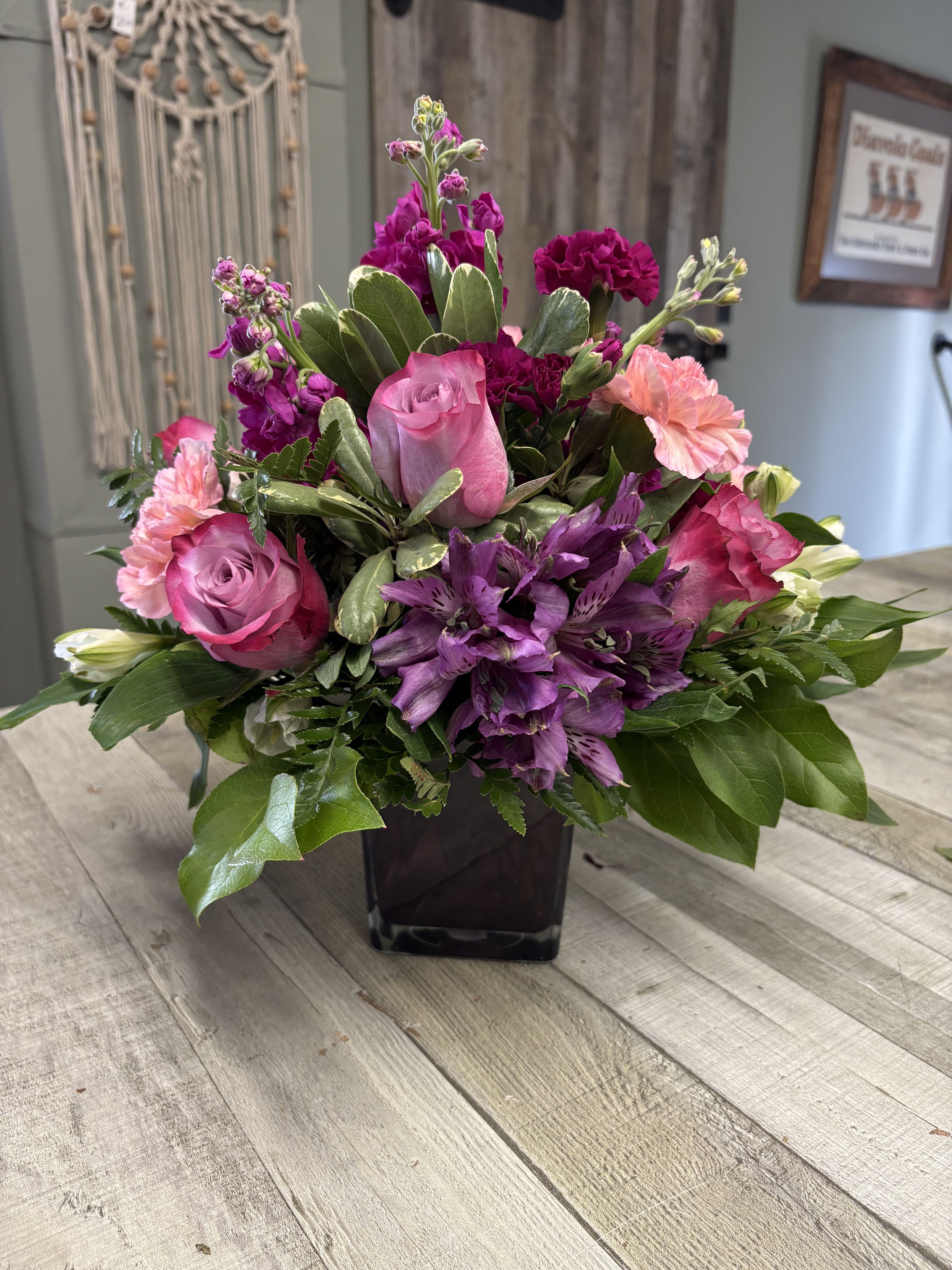 Pops of Lavender by BloomNation™ - Pop of Lavender by BloomNation™ is the perfect gift to wish someone a happy birthday or congratulations. Predominately purple and lavender flowers are the centerpiece of this purple-hued glass cube vase. 