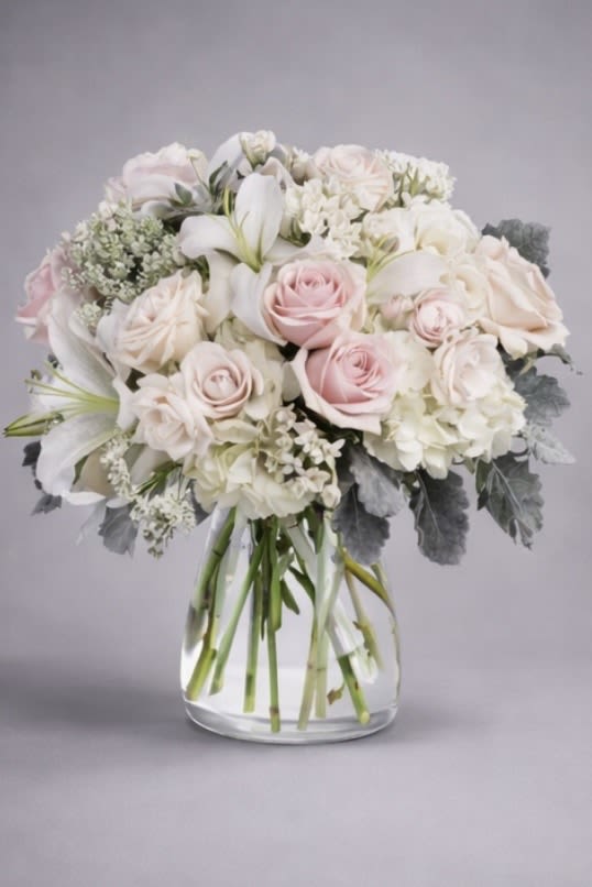 Blissful - This beautiful bouquet will most certainly arrive in style!  A delightful combination of light colors and lovely flowers, it's simply beautiful.  Light pink roses, white asiatic lilies, alstroemeria, cushion spray and more blooms are delivered in a stylish vase. Style to spare! 