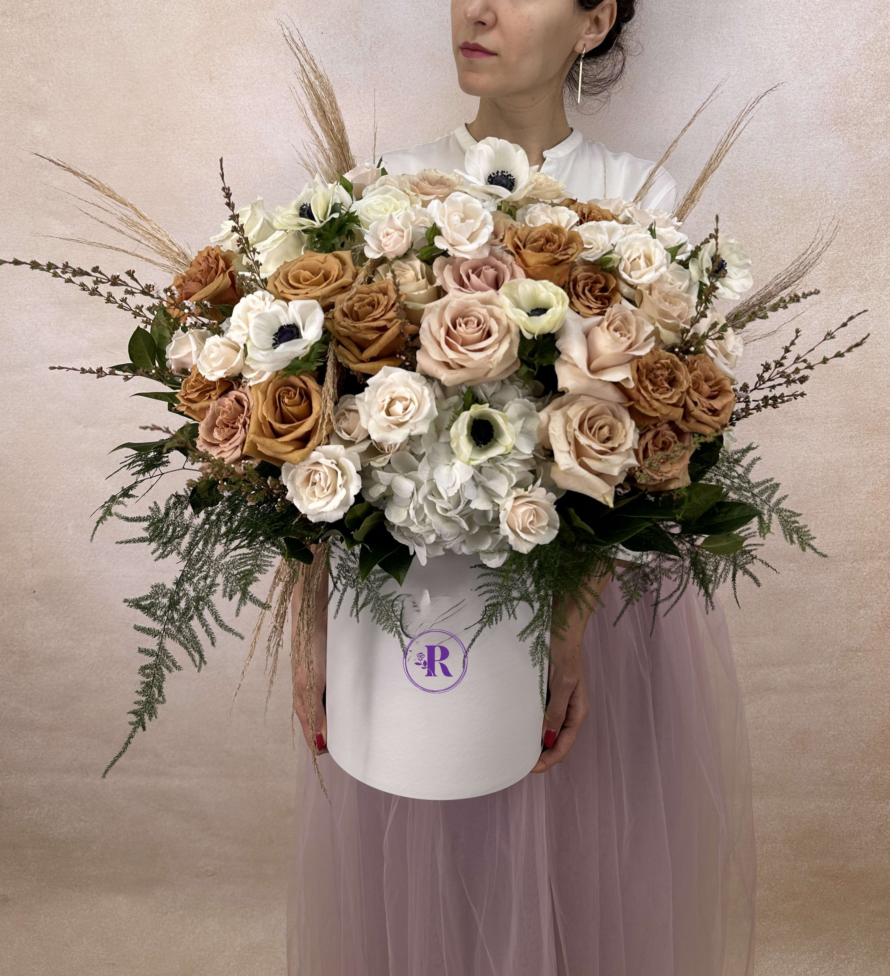 Boho style - An elegant Boho style arrangement featuring striking anemones, lush hydrangeas, delicate spray roses, and classic roses, enhanced by a selection of complementary seasonal blooms. This bouquet blends bold textures and soft colors, offering a sophisticated and timeless floral display perfect for special moments. The arrangement includes seasonal flowers. DELUXE size is shown in the photo.