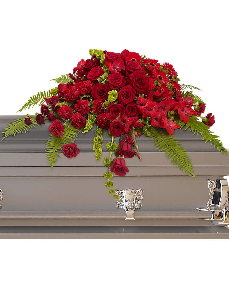 Red Rose Sanctuary Casket Spray - A gorgeous mix of dazzling red flowers will make a grand, yet graceful impression. Beautiful red roses, spray roses, gerberas, gladioli and carnations along with vibrant green bells of Ireland create a sincere tribute.