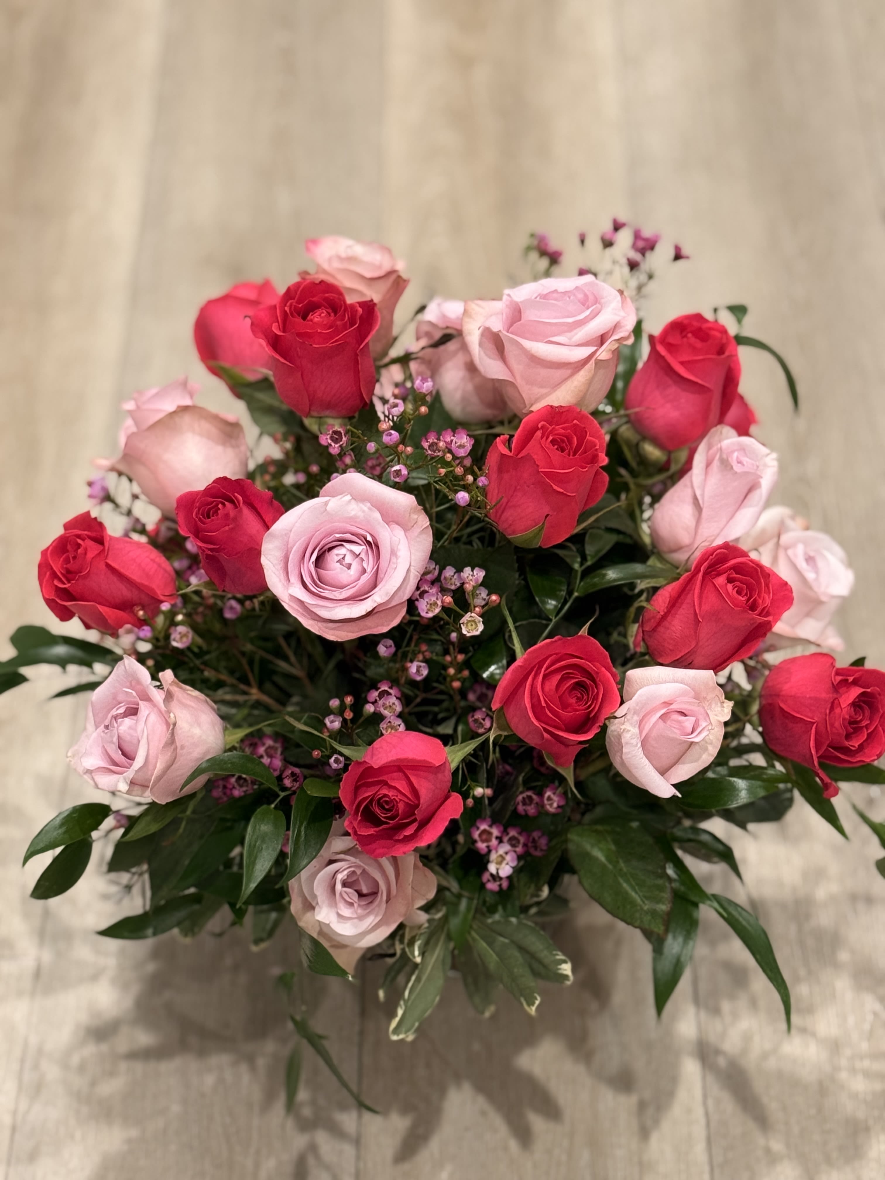 Pink Power - Short roses arrangement with light and hot pink roses, wax flower and greenery   24 roses