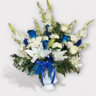 Blue &amp; White Symphony  - White lilies white roses and white stock encapsulated in greens and accented with blue rose or Delphinium  Blue Bow, White available upon request