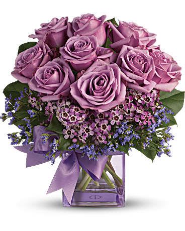Teleflora's Morning Melody One Dozen -  Beautiful blooms in all shades of purple are gathered into a purple glass cube vase and tied with a purple bow. How perfectly purple! A pretty taffeta ribbon puts the finishing touch on this presentation of lavender roses, lavender waxflower, purple limonium and rich green salal. Delivered in a purple glass cube vase. Orientation: All-Around  SUBSTITUTION POLICY – Always deliver the freshest flowers! Please note the bouquet pictured reflects our original design.  If the exact flowers or container in this arrangement are not available, our   florists will create a beautiful bouquet with the freshest available flowers.