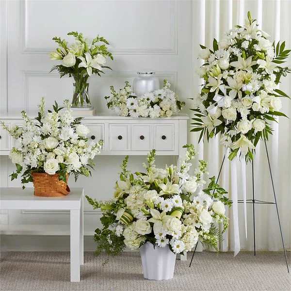 Sincerest Condolences Bundles  with Cremation Focus - As part of our Touching Tribute Collection, this set, resplendent in classic whites, features traditional arrangements meant for celebrating the life of a loved one at a visitation, funeral, church service, cremation, or cemetery service – or as a delivery to the home of the family.  Details The Standard Bundle includes our Eternal Friendship Bouquet and Heartfelt Condolences Arrangement. The Deluxe Bundle includes our Eternal Friendship Bouquet, Heartfelt Condolences Arrangement, and Thoughts of Tranquility Floor Basket. The Premium Bundle includes our Eternal Friendship Bouquet, Heartfelt Condolences Arrangement, Thoughts of Tranquility Floor Basket, and Exquisite Tribute Standing Spray. The Exquisite Bundle includes our Eternal Friendship Bouquet, Heartfelt Condolences Arrangement, Thoughts of Tranquility Floor Basket, Exquisite Tribute Standing Spray, and Timeless Tribute Cremation Adornment or Abundance Casket Spray. Designed by florists, ready to display. For long–lasting blooms, add water daily. Pet Safety Precautions: This bouquet or plant may include flowers and foliage that are known to be toxic to pets. To keep them safe, be sure to keep this arrangement out of your pet's reach.