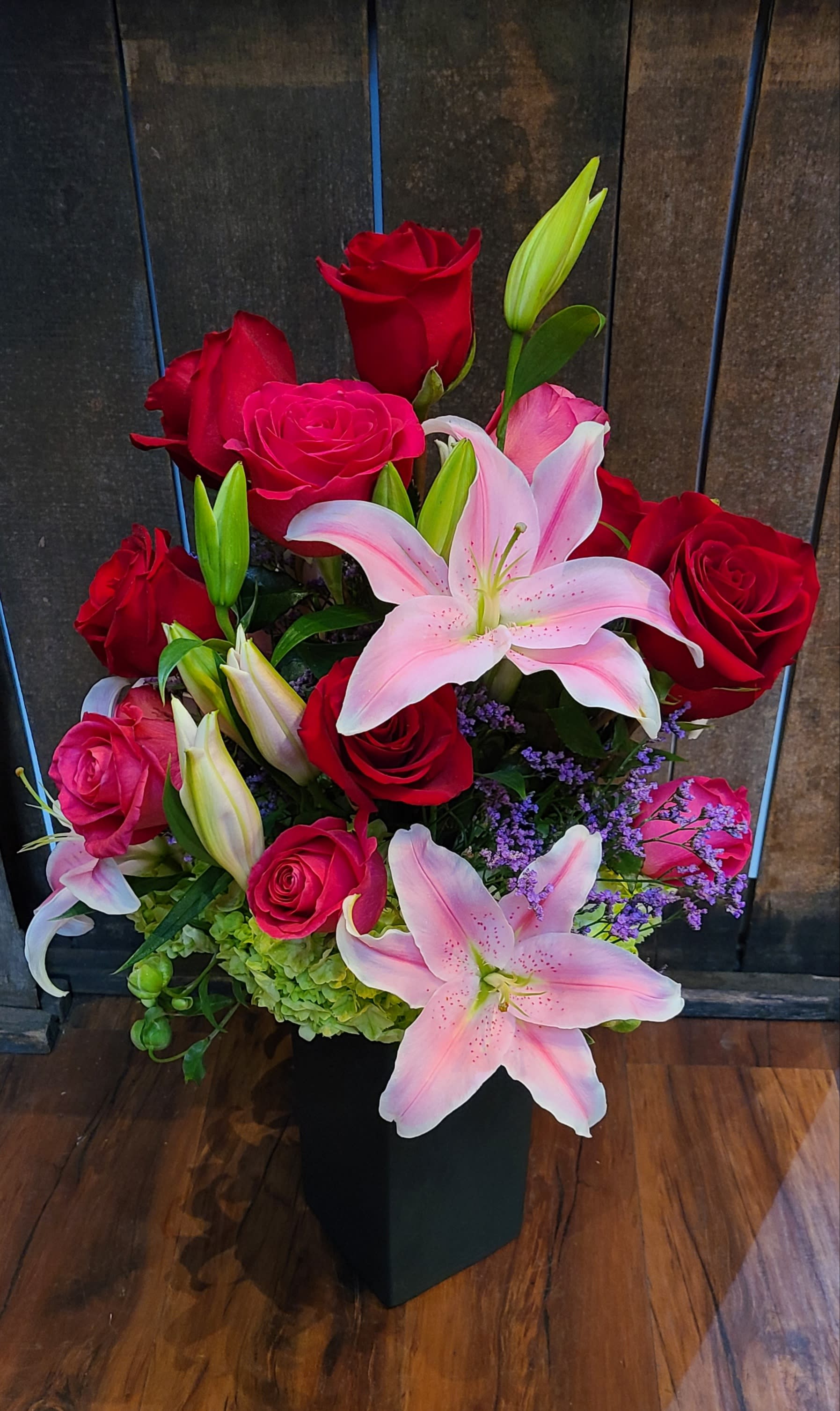 Lilies, roses and romance - This is a traditional arrangement, placed into a tall cylindrical vase and is designed with a 360° perspective.