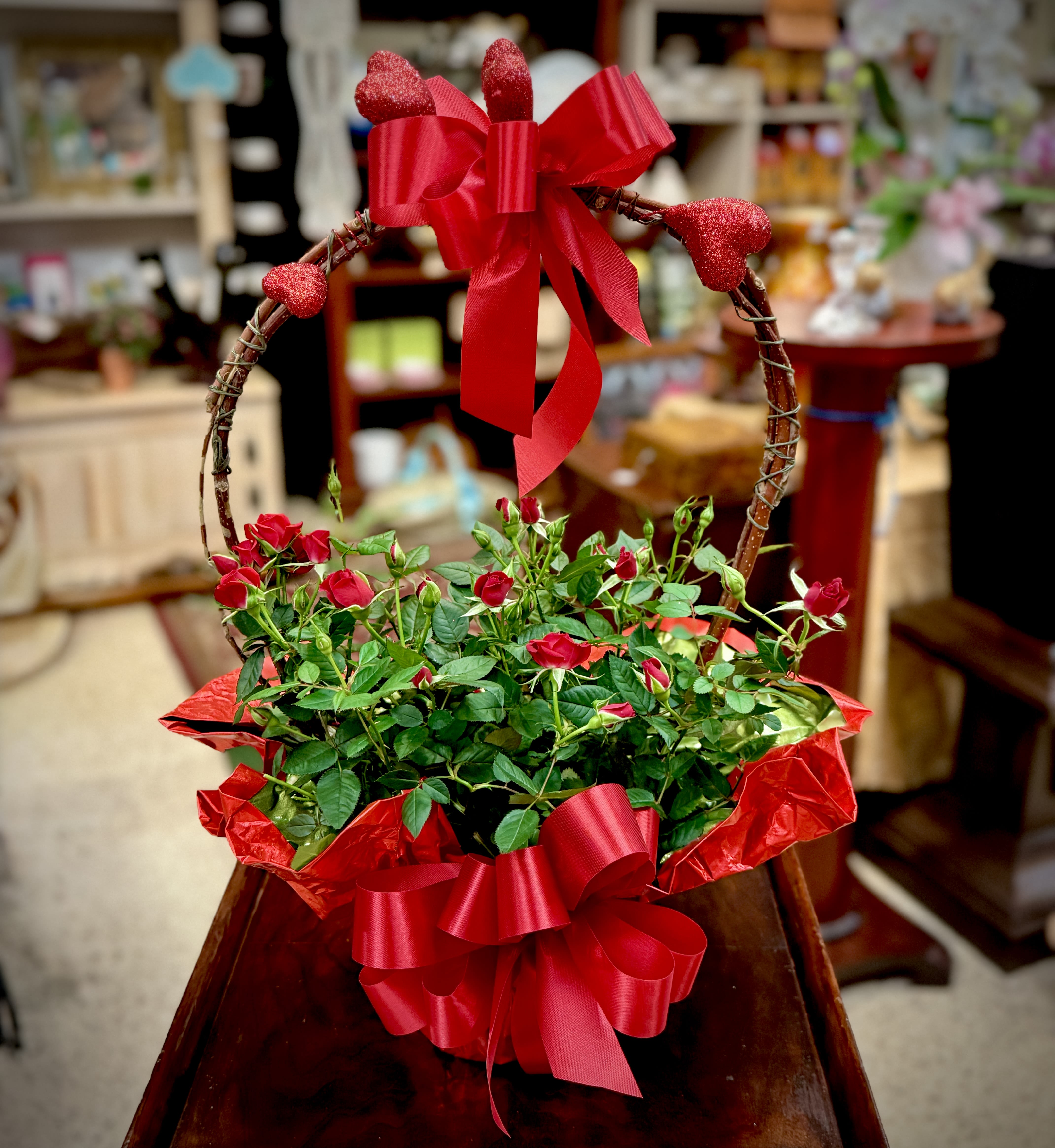 Red Mini Rose Plant - This red mini rose plant is filled with love and lots of buds! Dressed up extra special with a faux handle, ribbon, and glitter hearts. Approximately 20" H  We are proud to deliver our flower creations to the Kenosha, Somers, and Pleasant Prairie area. With over 55 years of combined flower design experience in Kenosha, Wisconsin, A Summer's Garden Florist and Gifts is the perfect choice for the freshest flowers, the most creative design, and exceptional customer service.