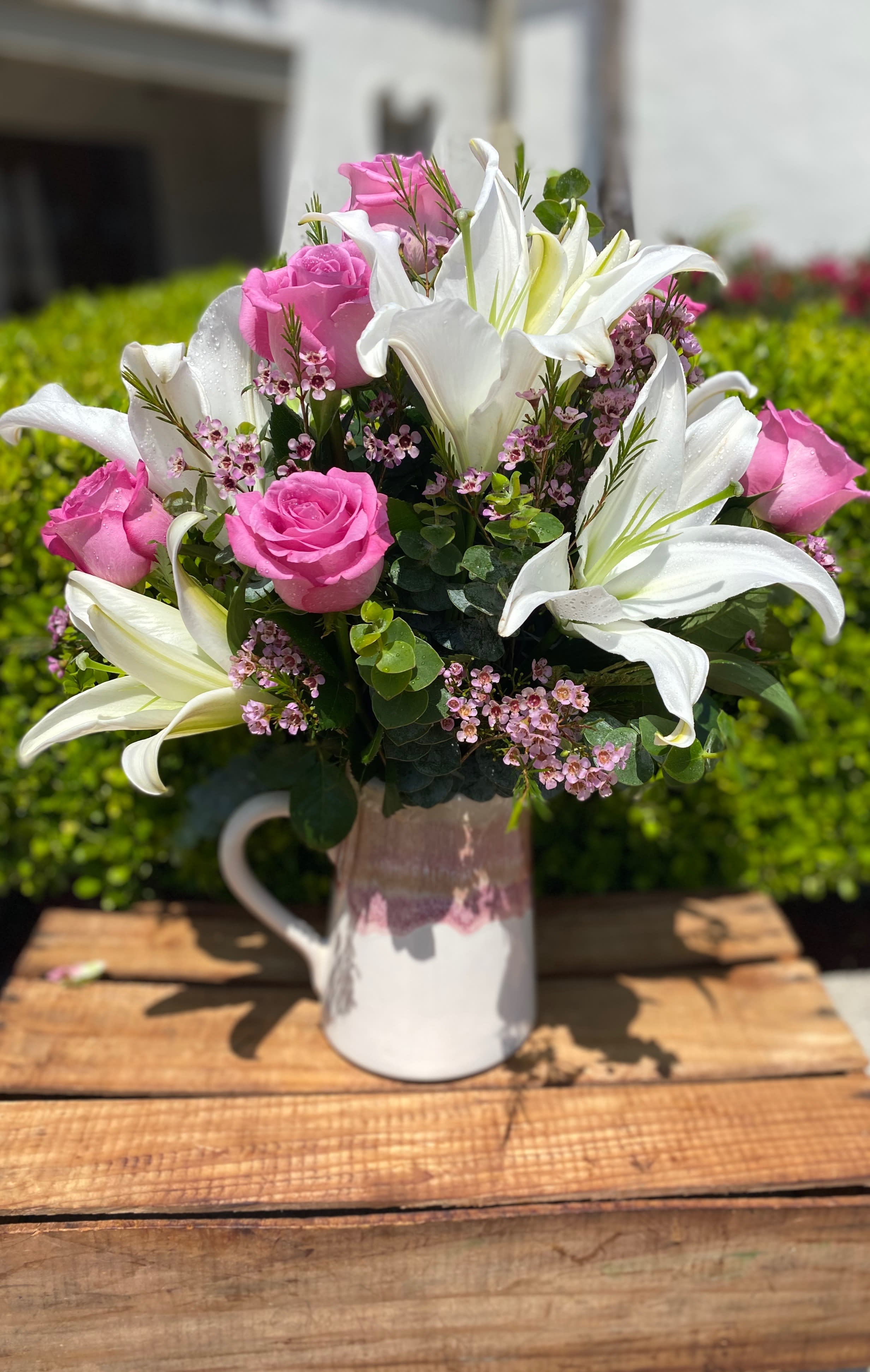 Embrace love  - lilies might be pink Don’t be shy embrace, love  let her know that you love her or just let her know that you’re thinking of her sending flowers is easy and the best wayThis beautiful arrangement comes in a classic white and pink pitcher vase. It has white Lily’s, Pink Roses, lavender wax, and mixed greens! This arrangement comes in a keepsake picture container. She will enjoy this beyond valentines day Floral design exclusive by Tommy Austin Florist.