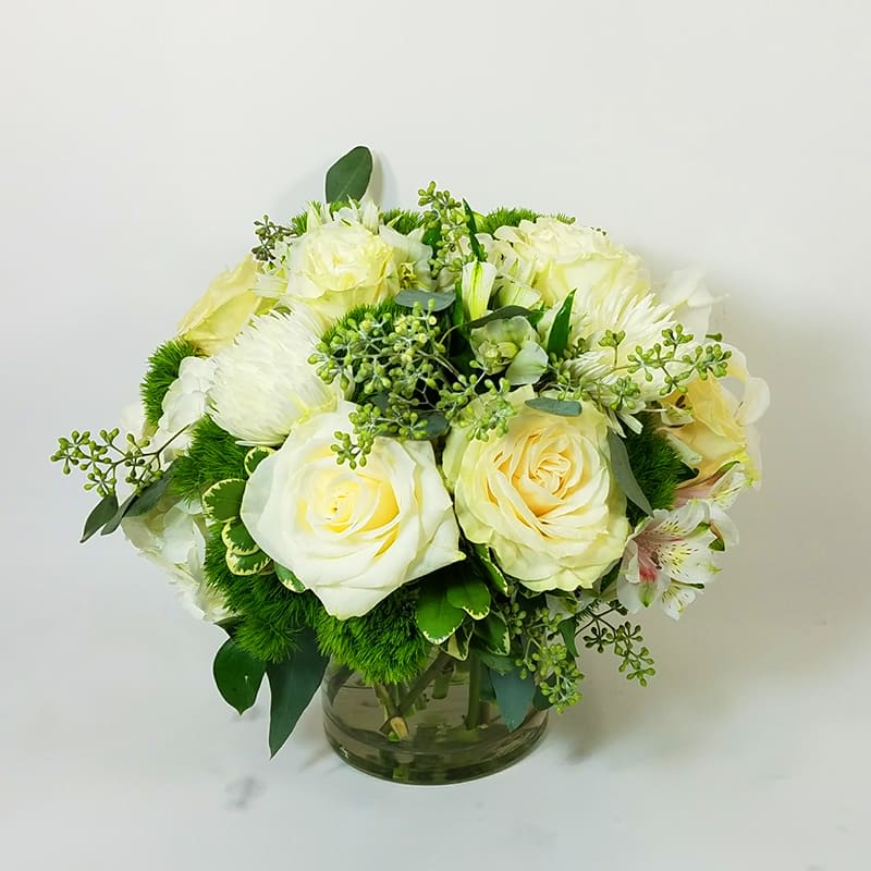 Simply White -  White Roses in a vase with greens and fillers. 