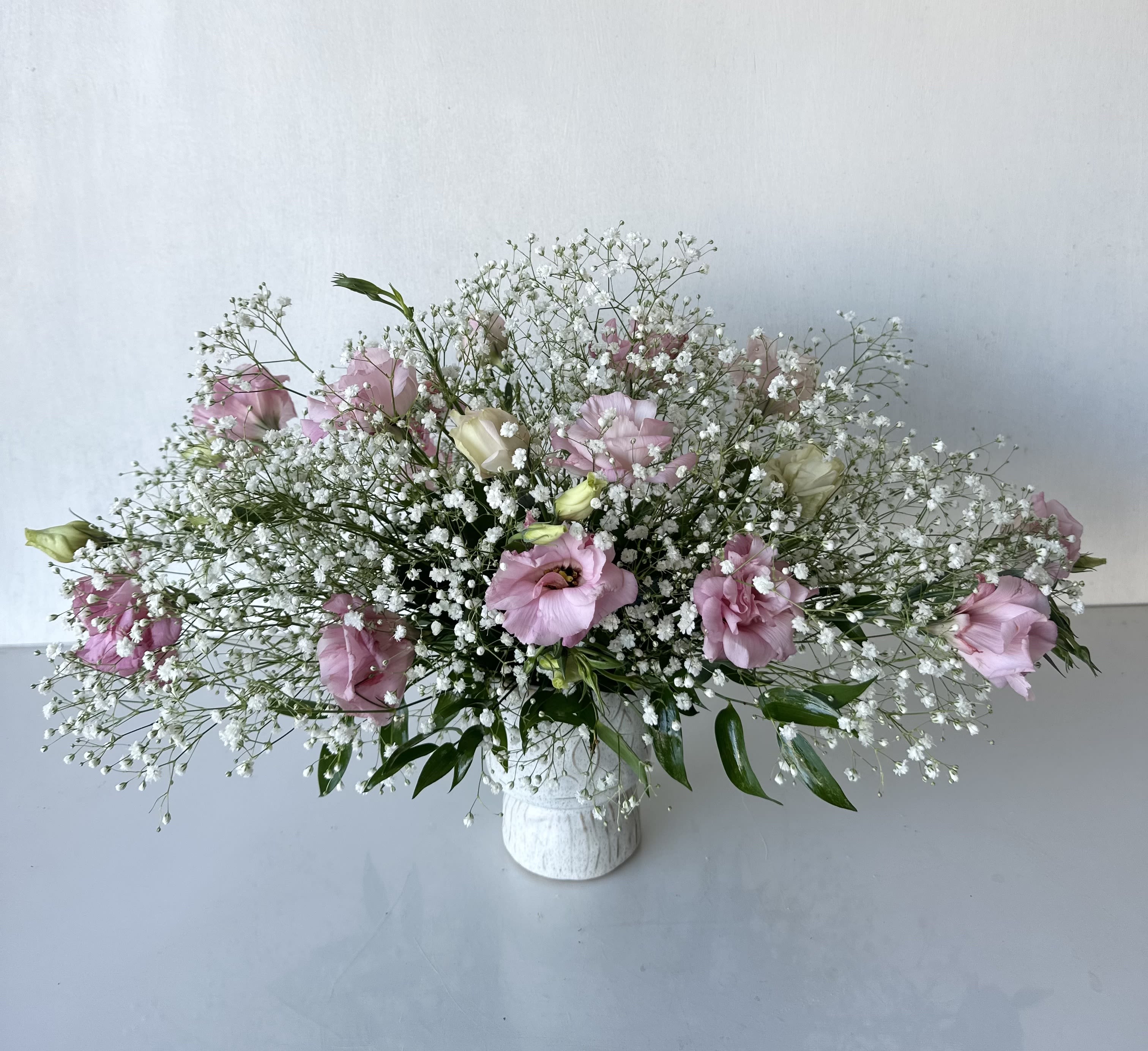 Simple Pleasure - A simple, modern arrangement of pink lisianthus and baby's breath. This floral design features a soft, elegant color palette. Dimensions: 14" H x 22" W  