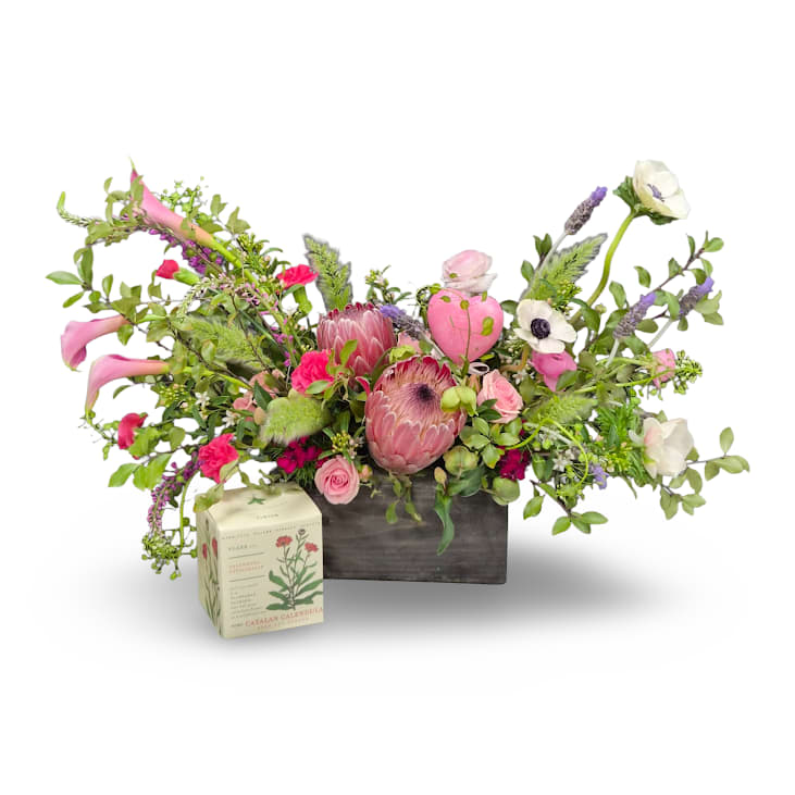 Garden Glamour Bundle - Garden Glamour paired with a single candle creates a refined and thoughtful gift. Featuring lush garden inspired blooms and flowing greenery, this bundle adds beauty, warmth, and a soft glow to any space.  Includes: -Garden Glamour Arrangement -Calendula KOBO Candle