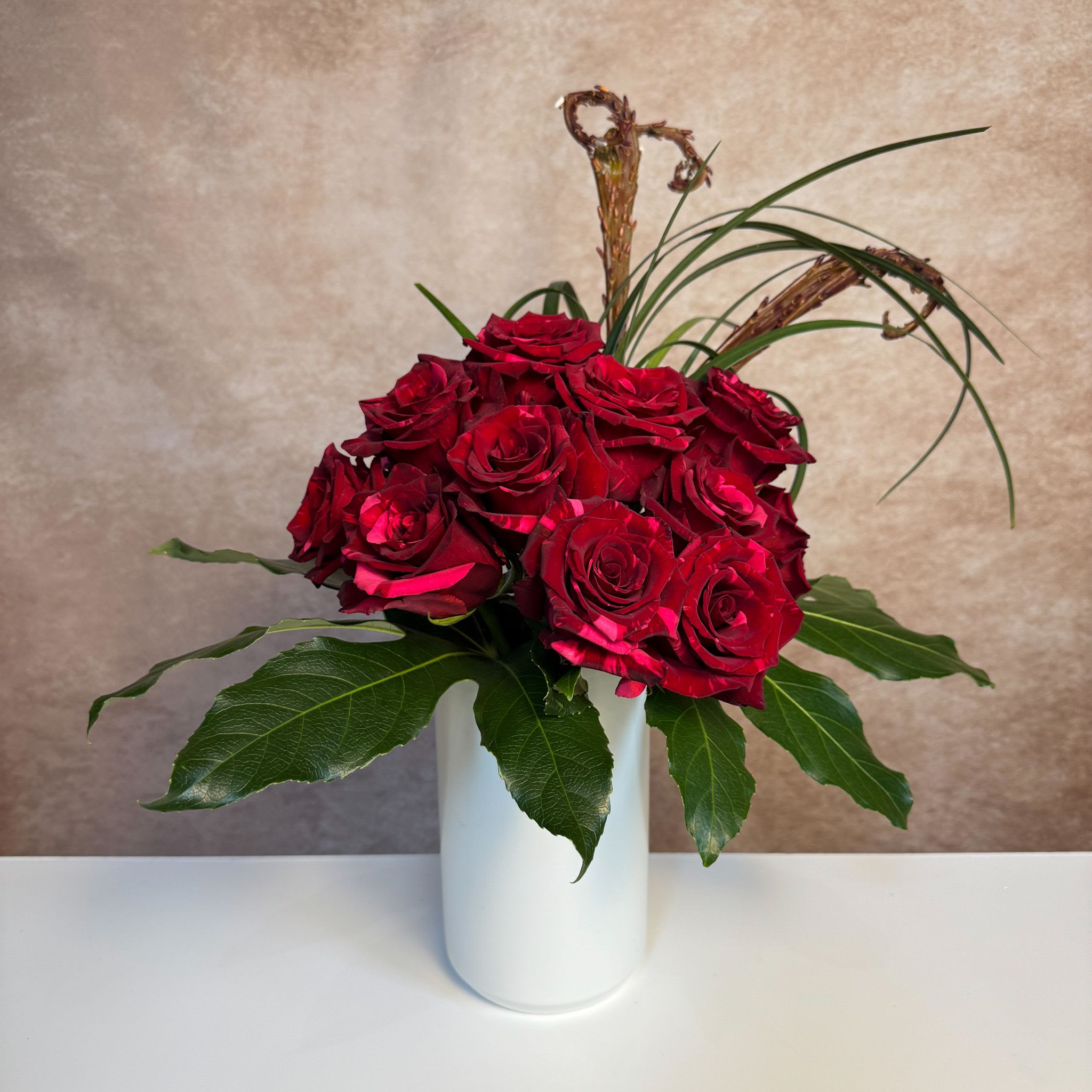 Modern Love - A modern take on our dozen roses, this arrangement includes a unique rose variety that is both red and pink, and tropical foliage and accents for a sophisticated twist. Upgrade to deluxe for additional roses.