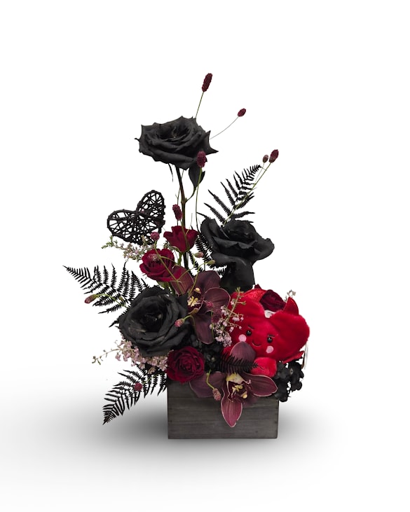 Obsidian Heart - Obsidian Heart is a striking Valentine’s arrangement featuring dramatic black roses accented with deep red blooms and rich textures. Finished with a red devil themed heart plush, this bold and unforgettable design makes a powerful statement of love. Approximately 20x11 inches.