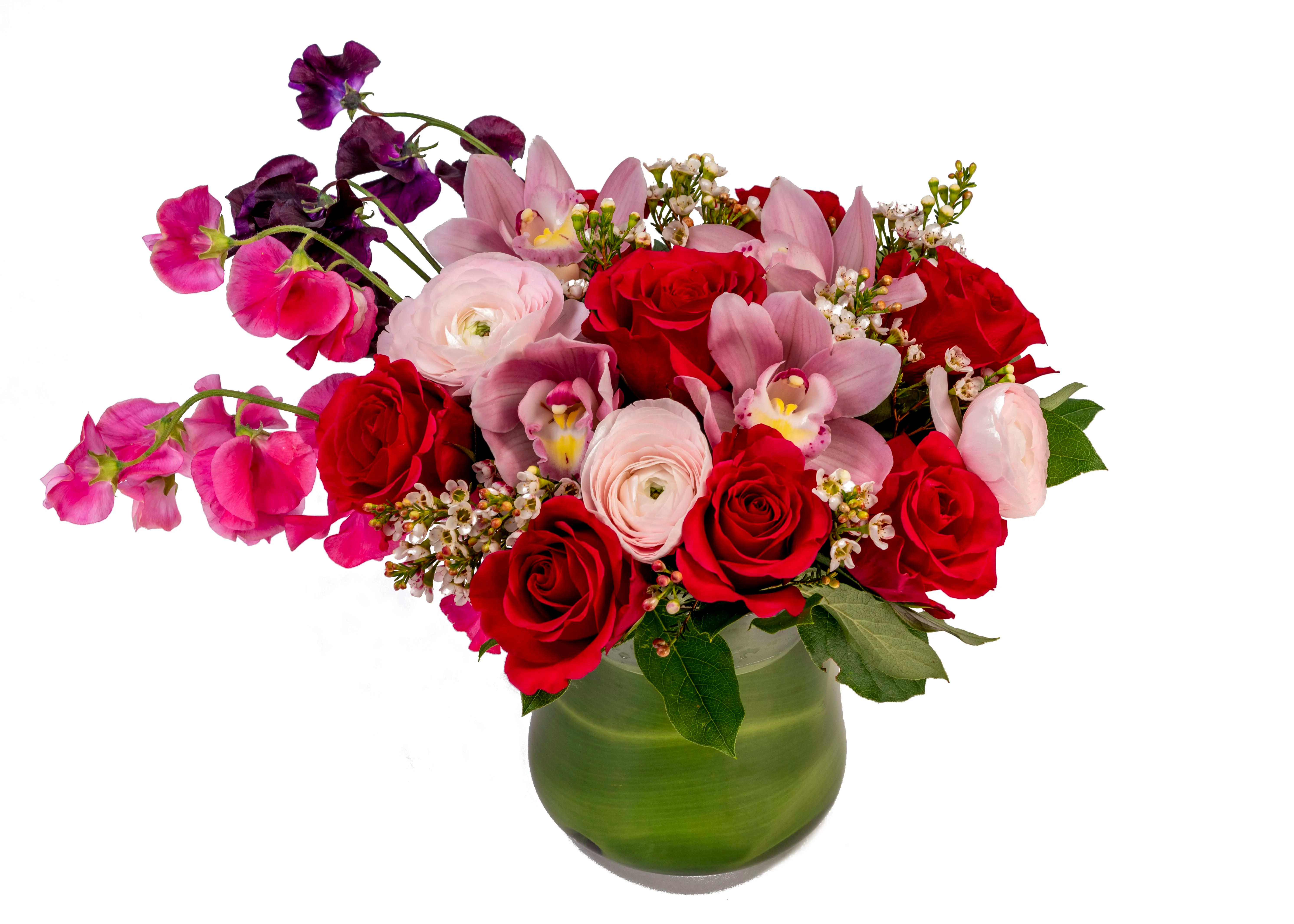 I Like You Alot  - Red roses, pink ranunculus, pink orchids &amp; pink and purple sweet pea arranged in a leaf wrapped glass vase with wax flower.