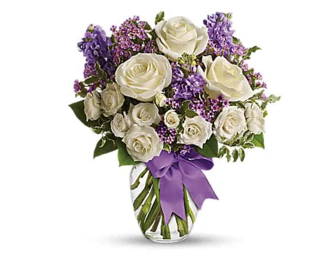 Enchanted Cottage - This magical bouquet will be at home in a cottage, a condo, a studio or an estate. It's so pretty it will be appreciated by all those lucky enough to receive it. Enchant someone today! White roses and spray roses, lavender stock and waxflower, all perfectly arranged in a clear glass vase that's wrapped with purple ribbon.   Orientation : One-Sided  All prices in USD ($)  Standard  T50-1A  Deluxe  T50-1B  Premium  T50-1C
