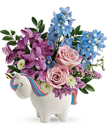 Enchanting Pastels Unicorn Bouquet - Pale pink roses and pretty pastel petals look oh-so-enchanting in this sweet ceramic unicorn with golden horn and hand-painted details! This enchanting arrangement features light pink roses, purple alstroemeria, light blue delphinium, white button spray chrysanthemums, pink sinuata statice, and huckleberry. Delivered in a Charmed Unicorn Keepsake. 