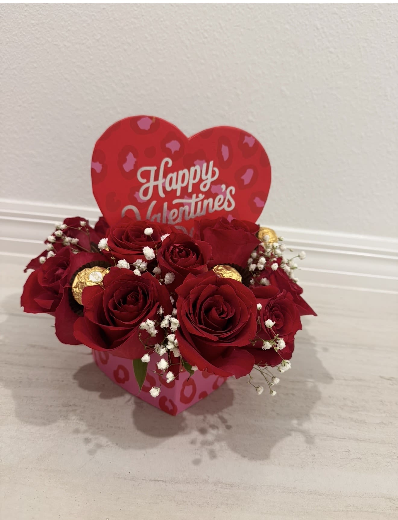 Happy Valentine’s Love Box - A romantic Valentine’s arrangement featuring fresh red roses beautifully arranged in a heart-themed box, accented with delicate baby’s breath and Ferrero Rocher chocolates. Topped with a charming heart sign that reads “Happy Valentine’s,” this elegant design is perfect for expressing love, passion, and heartfelt emotions. Ideal for Valentine’s Day, anniversaries, or a sweet romantic surprise.