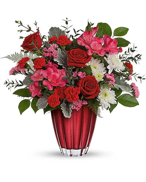 SOPHISTICATED LOVE BOUQUET - Sleek and sophisticated, this stunning Valentine's Day surprise features lush red and pink blooms presented in a beautiful vase of European glass with ombre metallic finish. This sophisticated bouquet includes red roses, miniature red carnations, pink alstroemeria, white cushion spray chrysanthemums, pink sinuata statice, leatherleaf fern, parvifolia eucalyptus, lemon leaf, and dusty miller. Delivered in a Sophisticated Love vase.