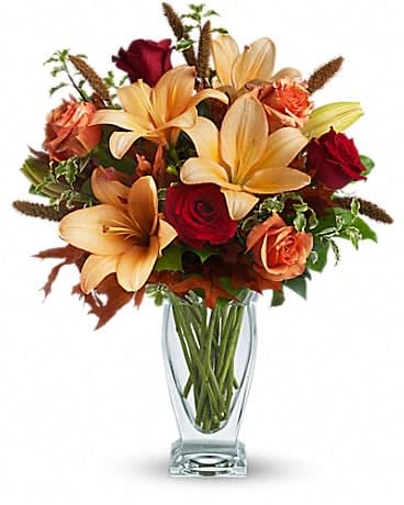 Fall Fantasia - Absolutely exquisite! This bouquet is a fall flower fantasy come true. All the richness of this colorful season is captured in a stylish glass vase. So pretty, you might have to order one for a friend and one for yourself! Beautiful orange and red roses, yellow asiatic lilies, autumn oak leaves and more are beautifully arranged in an exclusive Couture Vase. Isn't fall fantastic? 