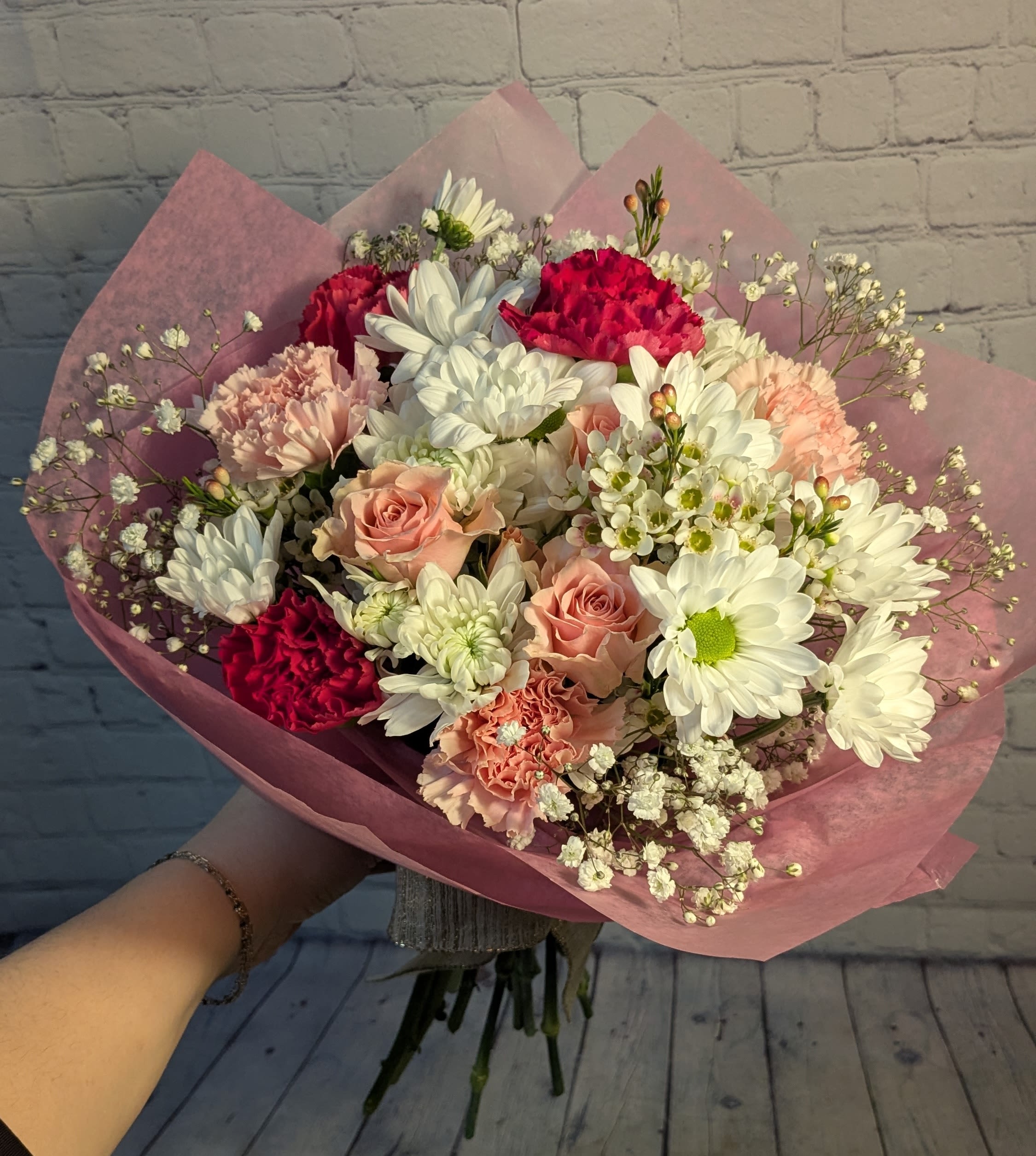 Make Me Blush - A hand-tied mix of white &amp; pink floral. Including: white daisies, pink spray roses, pink carnations, wax flower, &amp; gyp. *Product does not include a vase/container. This is a hand-tied bouquet. 