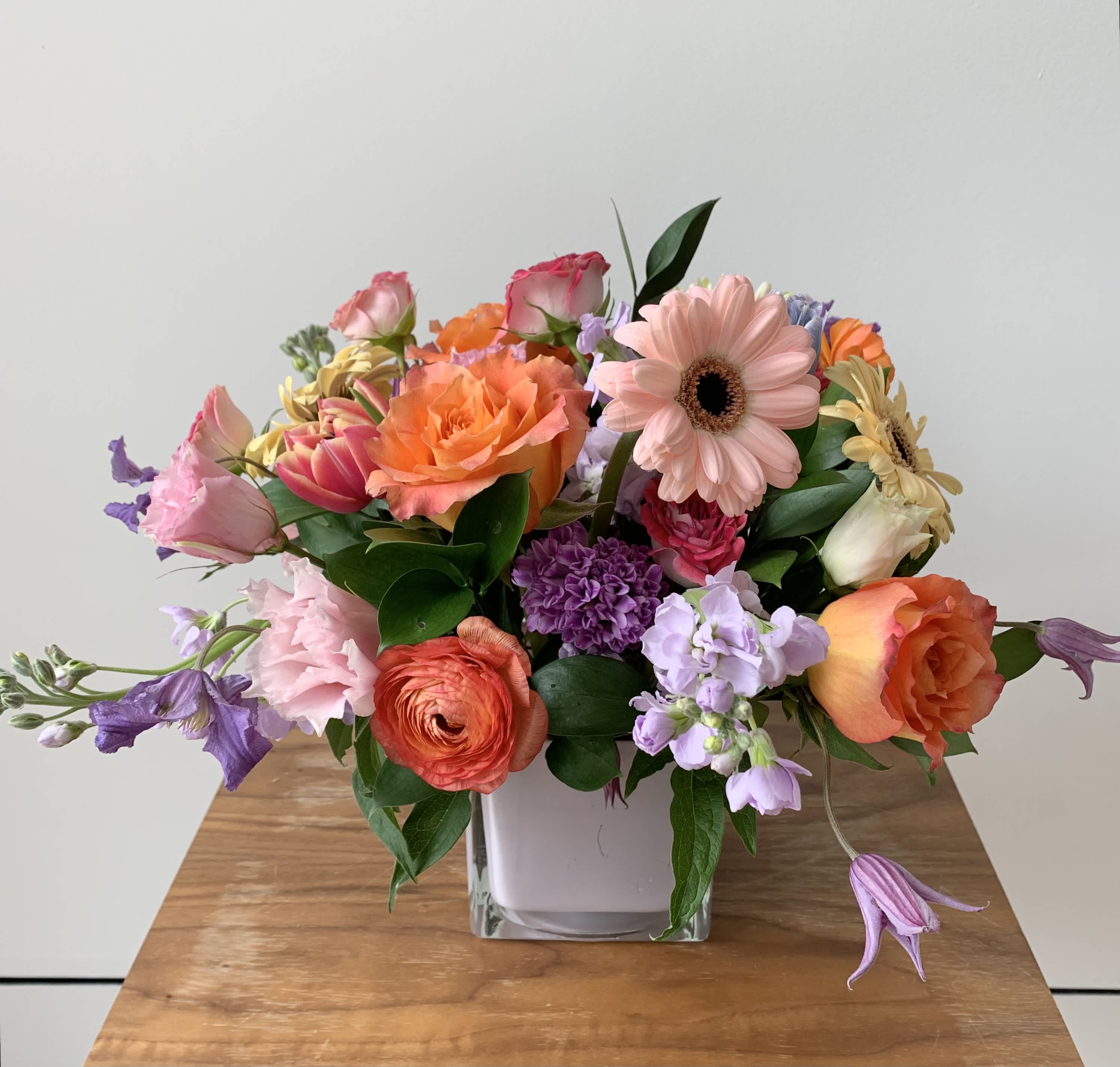 Floral Fling - A short flower arrangement in a 5inch white cube with a variety of colorful flowers. A perfect seasonal flower gift or a piece of living floral decor for your home.