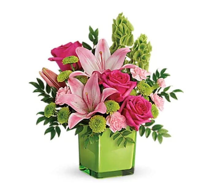In Love With Lime Bouquet - Lime-a-licious! Fresh shades of green are a great way to contrast pink roses and lilies. Hand-delivered in a lovely leaf green cube, it's a loving gift any day of the week! This refreshing arrangement features dark pink roses, pink asiatic lilies, pink miniature carnations, bells of ireland, green button spray chrysanthemums, and huckleberry. Delivered in a glass cube.Approximately 14" W x 15" H 