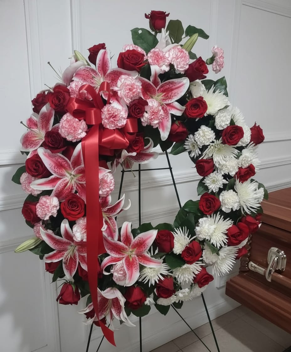 Red and White  Funeral Wreath - This beautiful wreath is a soothing mix of red and white roses and mums with an accent of oriental lilies 