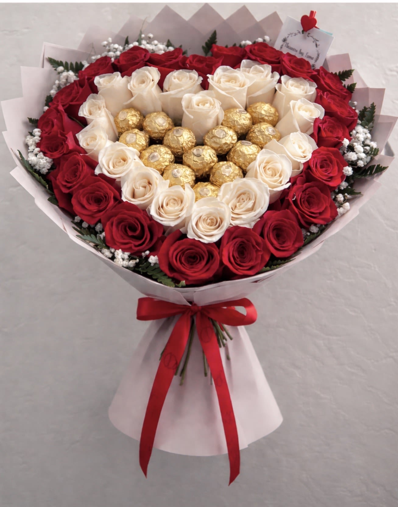 Heart of Endless Love 	 - Product Description (BloomNation): This luxurious heart-shaped bouquet features a breathtaking arrangement of 24 red roses and 12 white roses, symbolizing deep love and pure elegance. At the center, 12 premium Ferrero Rocher chocolates add a sweet and indulgent touch. Beautifully hand-wrapped in soft pink paper and finished with a rich red satin ribbon, this stunning design is perfect for Valentine’s Day, anniversaries, birthdays, or any unforgettable romantic occasion