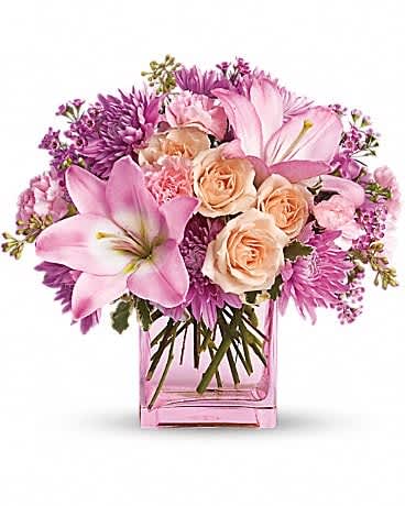 Teleflora's Possibly Pink - Impossibly pretty. This decidedly feminine arrangement is absolutely delightful. Perfectly peachy peach spray roses, pink asiatic lilies and miniature carnations, lavender cushion spray chrysanthemums and waxflower, pittosporum and seeded eucalyptus fill an exclusive pink cube. Have one delivered and almost anything's possible.