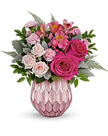 Teleflora's Pretty Love Bouquet - Keep 'em blushing with the prettiest pink roses, presented to perfection in a sculpted pink glass vase with a fabulously frosted, faux mercury glass finish. This arrangement features hot pink roses, light pink spray roses, dark pink alstroemeria, miniature pink carnations, pink sinuata statice, dusty miller, huckleberry and leatherleaf fern. This perfectly pink bouquet is delivered in a Pretty Love Vase.