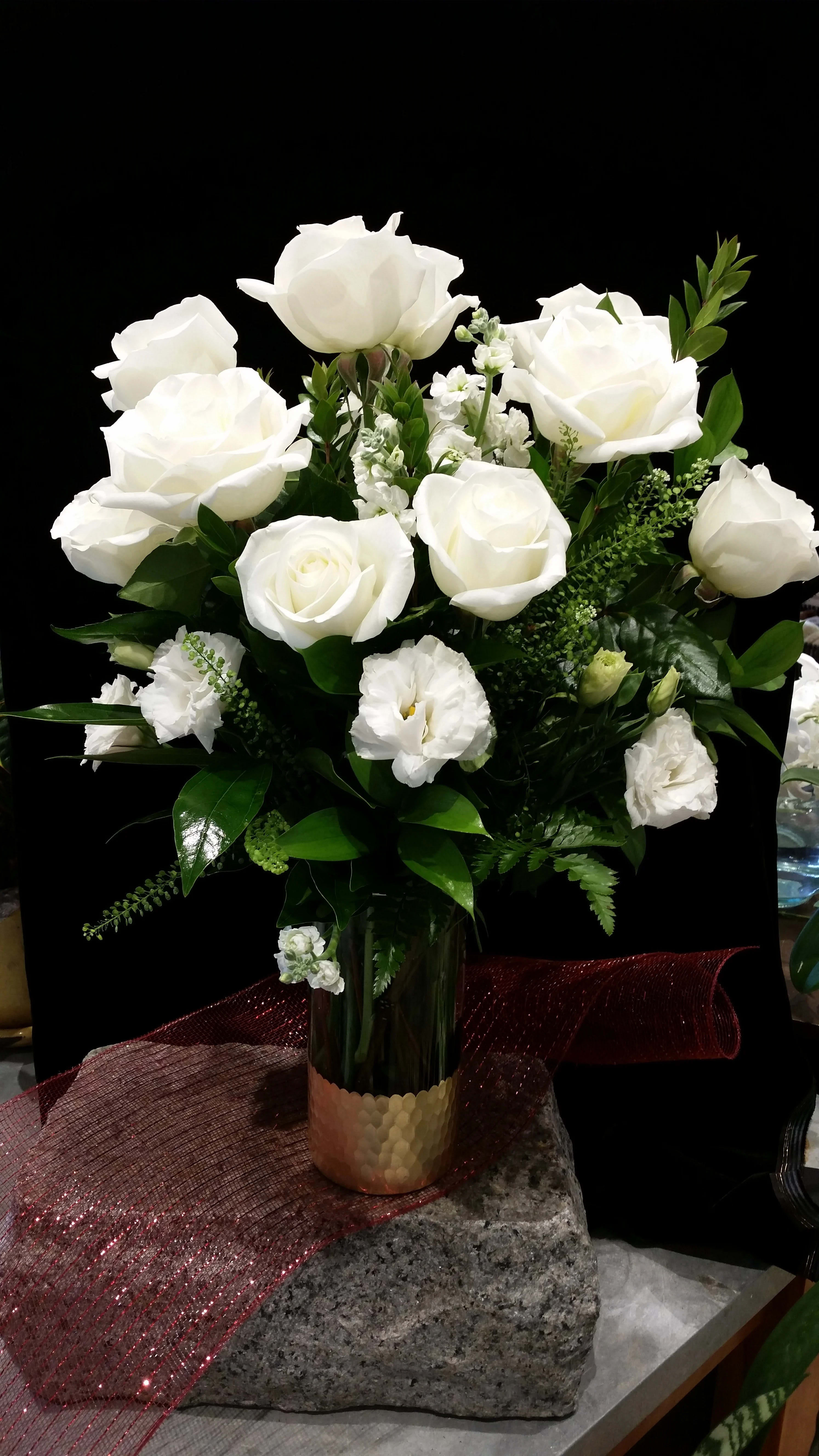 Snow White Dozen Roses  - Pure, innocent, stunning white roses make a lovely presentation in a clear vase.  One dozen premium, long stemmed white roses fill a lovely vase with dark greenery for accent.  This is a true classic that is perfect for a special occasion in your life!  