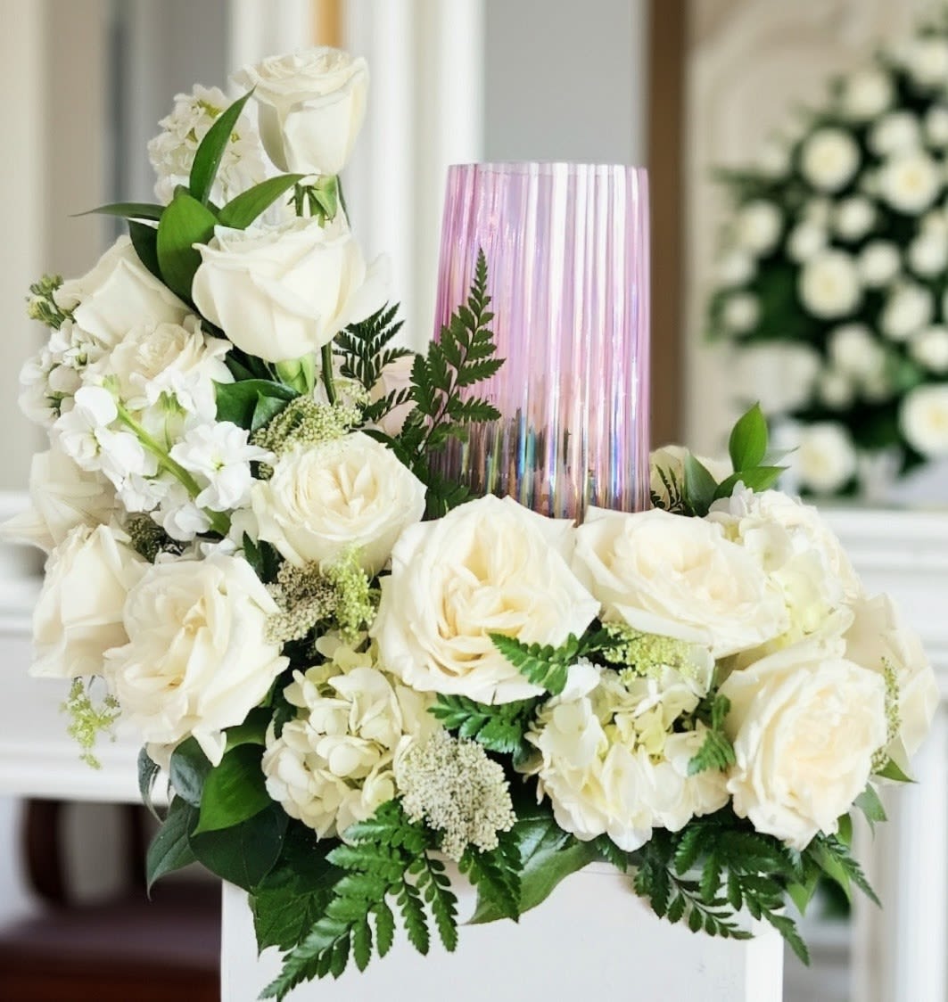 Peaceful Harmony Urn Arrangement  - The is has several soft white roses, white stock flower, hydrangea, and a white filler with foliage at a minimum. It is soft and gently to company a beautiful  urn. Please provide urn size and upgrade if urn is larger than 5x5