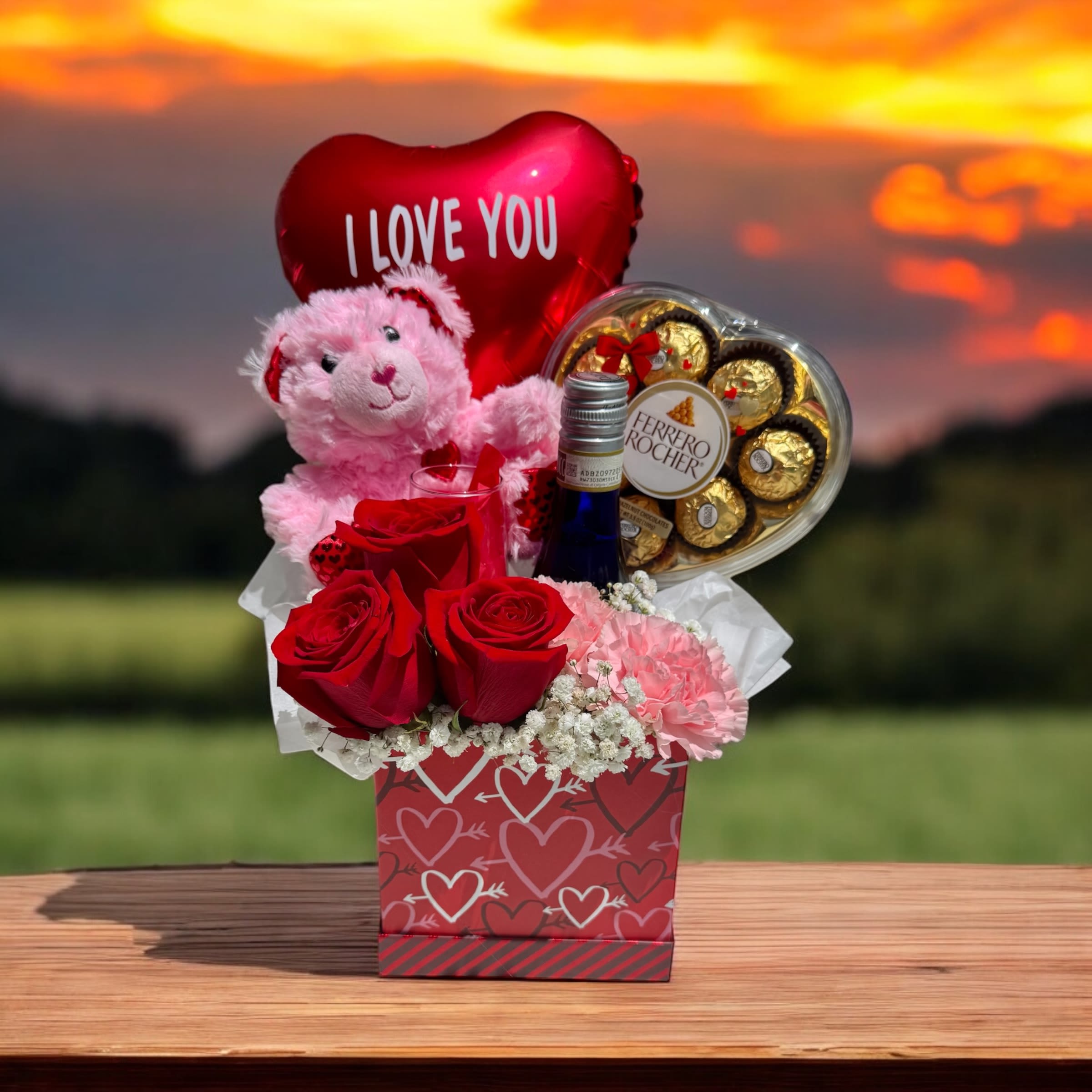 Drunk In Love - Sweet Love is the ultimate expression of affection, combining heartfelt gifts and beautiful blooms in one unforgettable surprise. Featuring classic red roses, soft pink carnations, and delicate baby’s breath, this floral arrangement is paired with a cuddly teddy bear, an 'I Love You' balloon, a decadent Ferrero Rocher heart, and a bottle of Rissato Moscato. Thoughtfully curated to delight her senses and her heart, it’s a luxurious way to say, 'I love you'.