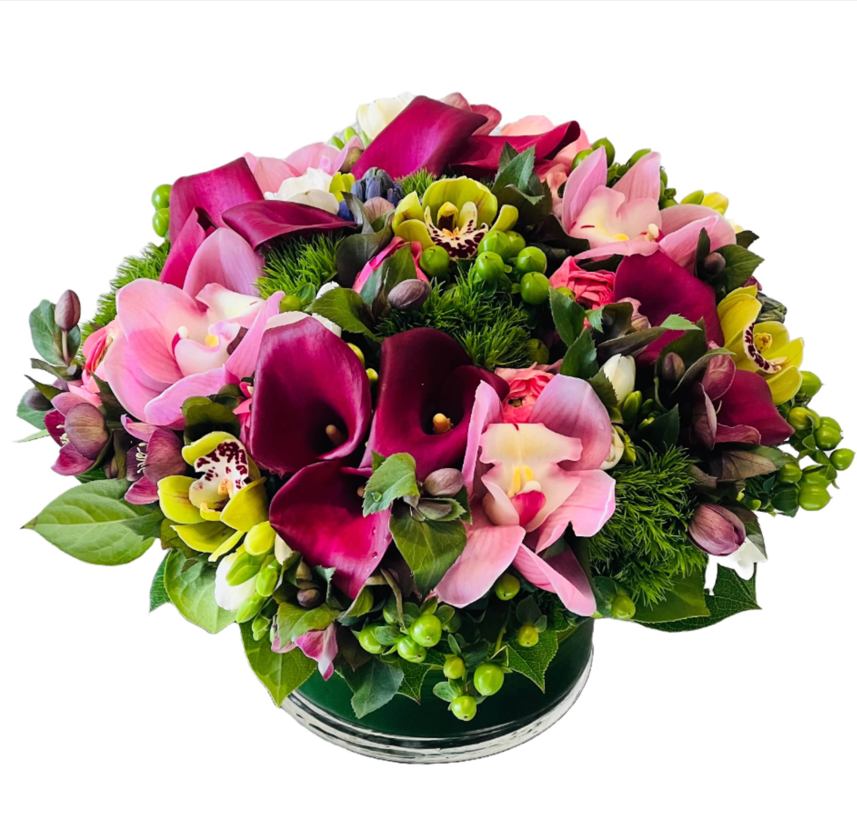 Muse - This enchanting arrangement is a combination of romantic pinks curated to captivate hearts. This elegant ensemble features an array of delicate blooms in shades of blush, rose, and soft pink, intertwining to create a tender and elegant expression of love.  Please note: the Standard size is a small arrangement. Photos are often styled close-up and can appear larger than the actual size. If you’re looking for a fuller, more impactful look, we recommend choosing a larger size.