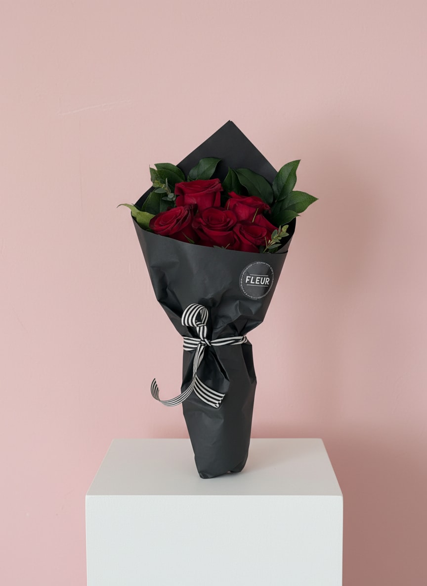 4 | Bouquet de Roses Rouges Enveloppé Noir - A true classic that everyone loves! Red roses wrapped in black paper. Includes floral hydration so the flowers stay fresh.