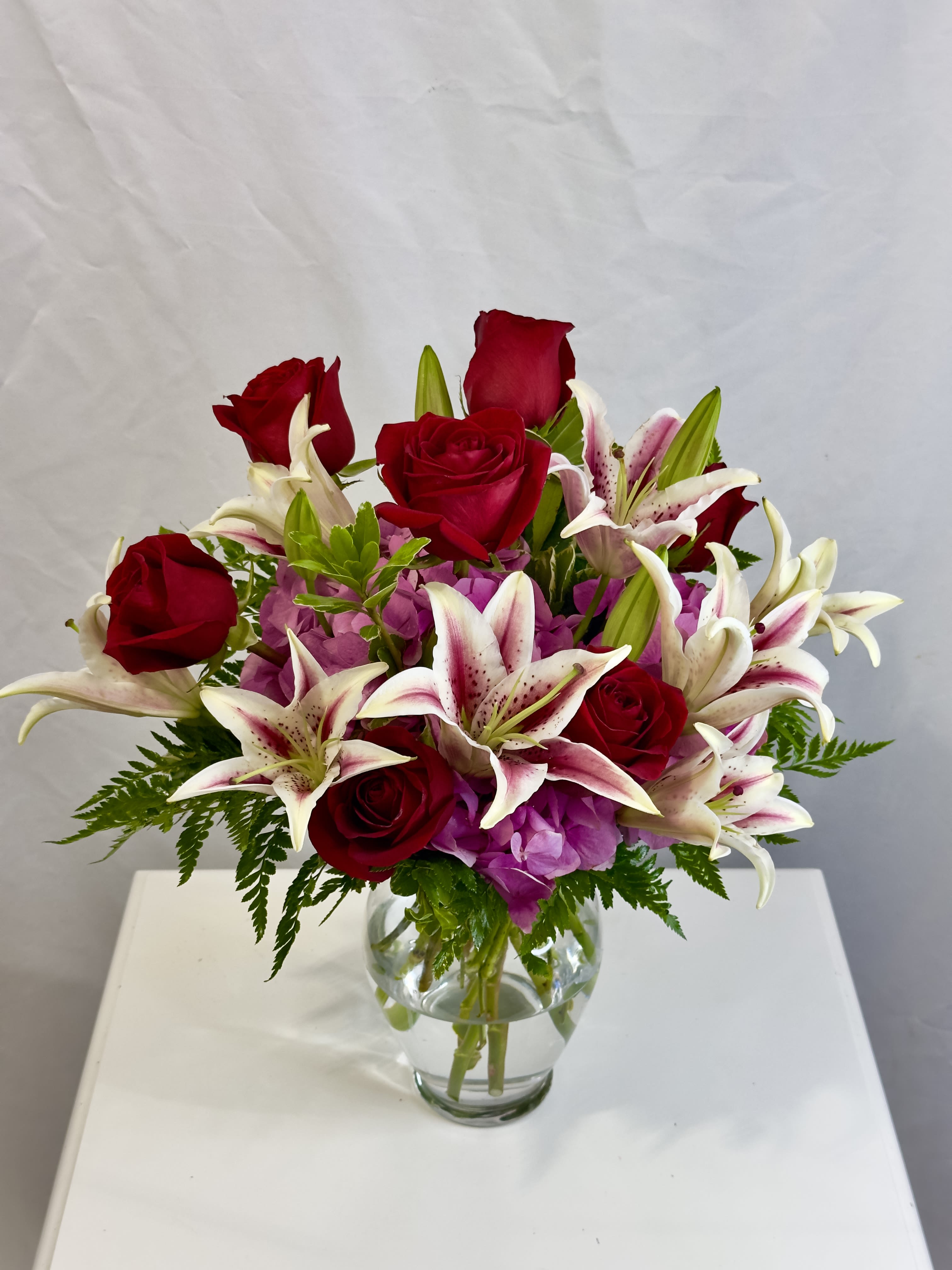 Lavish Love - Stunning Stargazers, Fuchsia Hydrangeas, and Ecuadorian red Roses nestled in lush green foliage