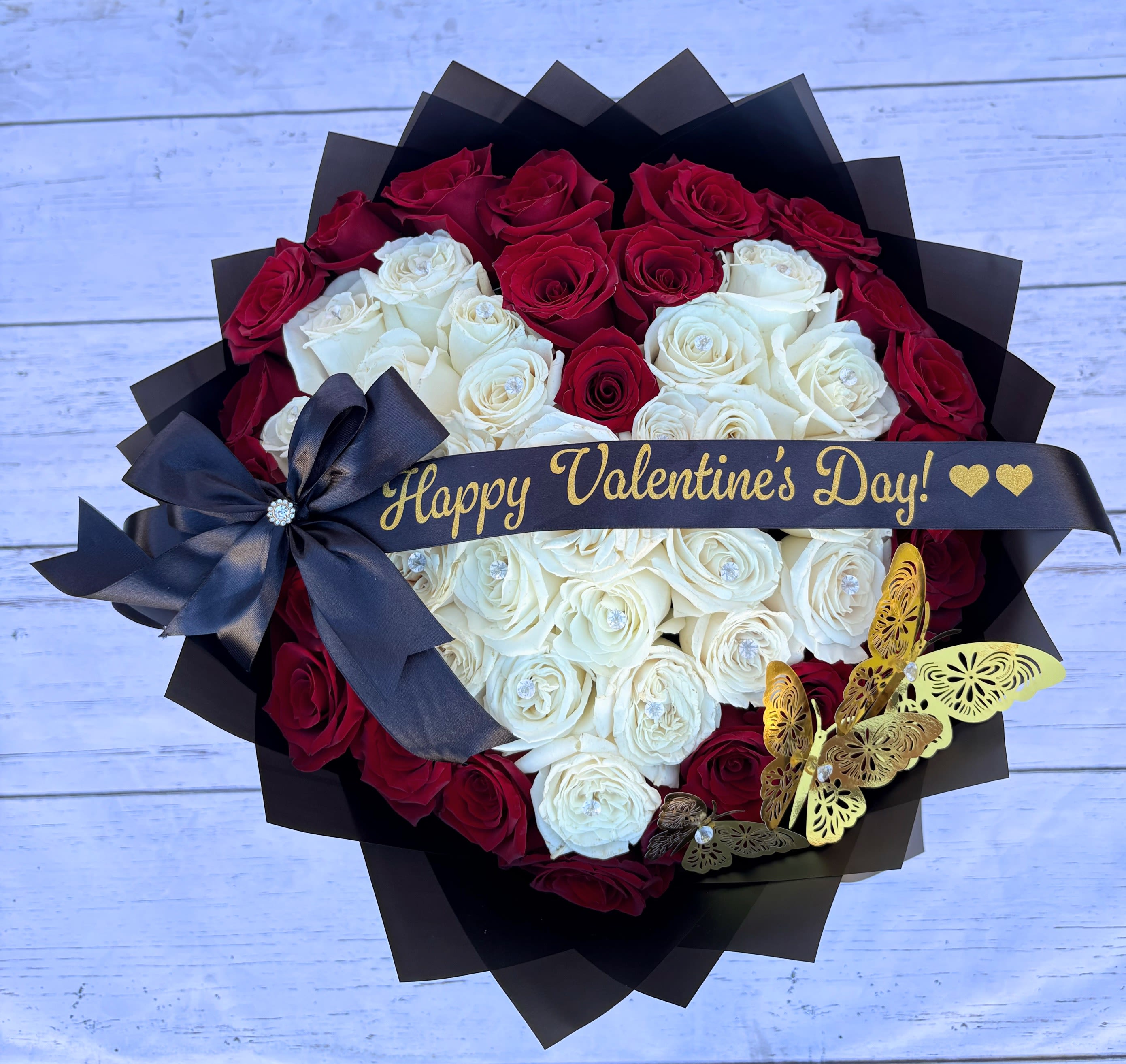 My beautiful Heart - 48 red roses arranged in a heart shape, wrapped in black paper, with butterflies and a designer ribbon.