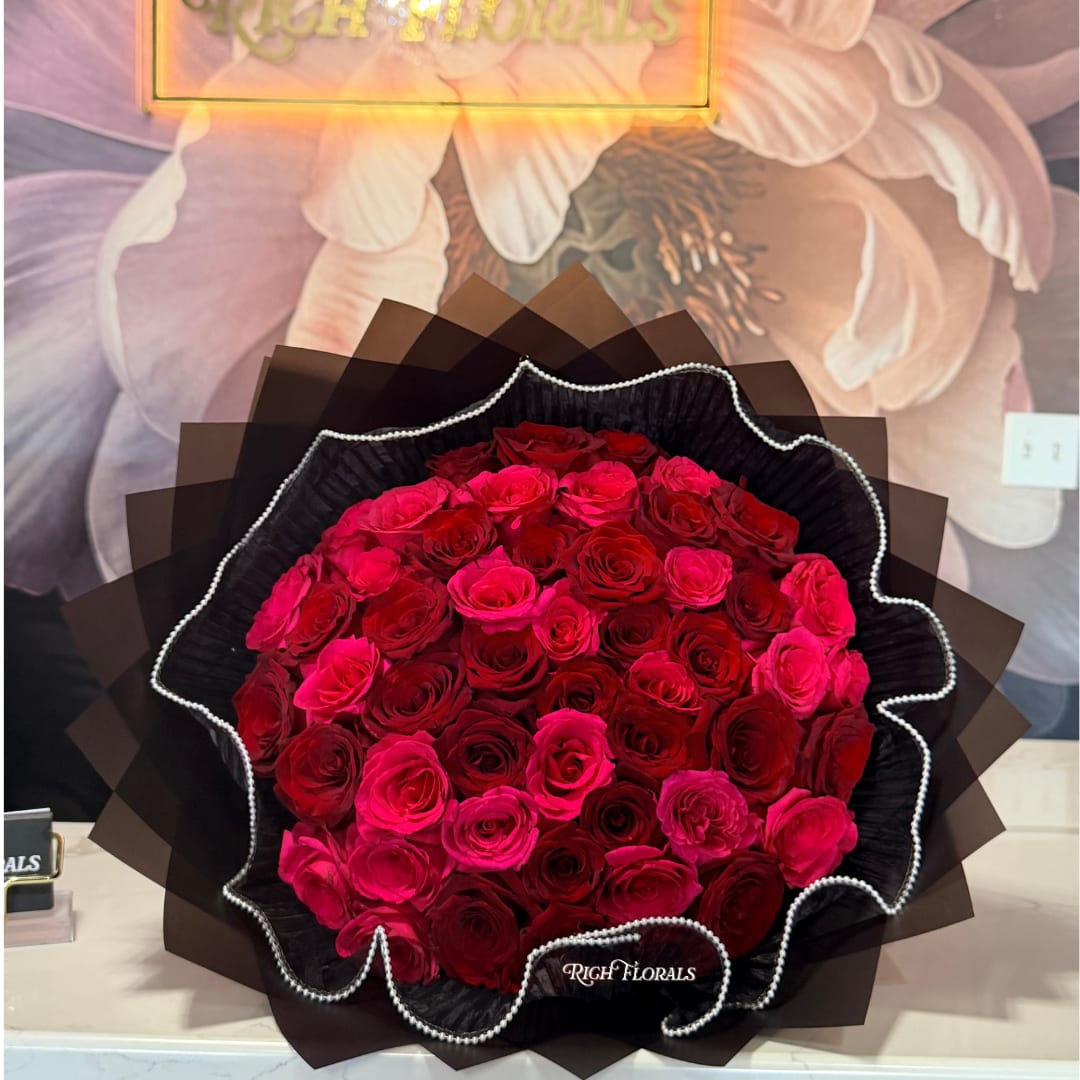 The Denaya Bouquet - Hot pink and red roses wrapped in black paper with black pearl mesh detailing. The CEO's personal favorite. Perfect for Valentine's Day, anniversaries, birthdays, Mother's Day, or just because. Available in 36, 50, or 75 roses.