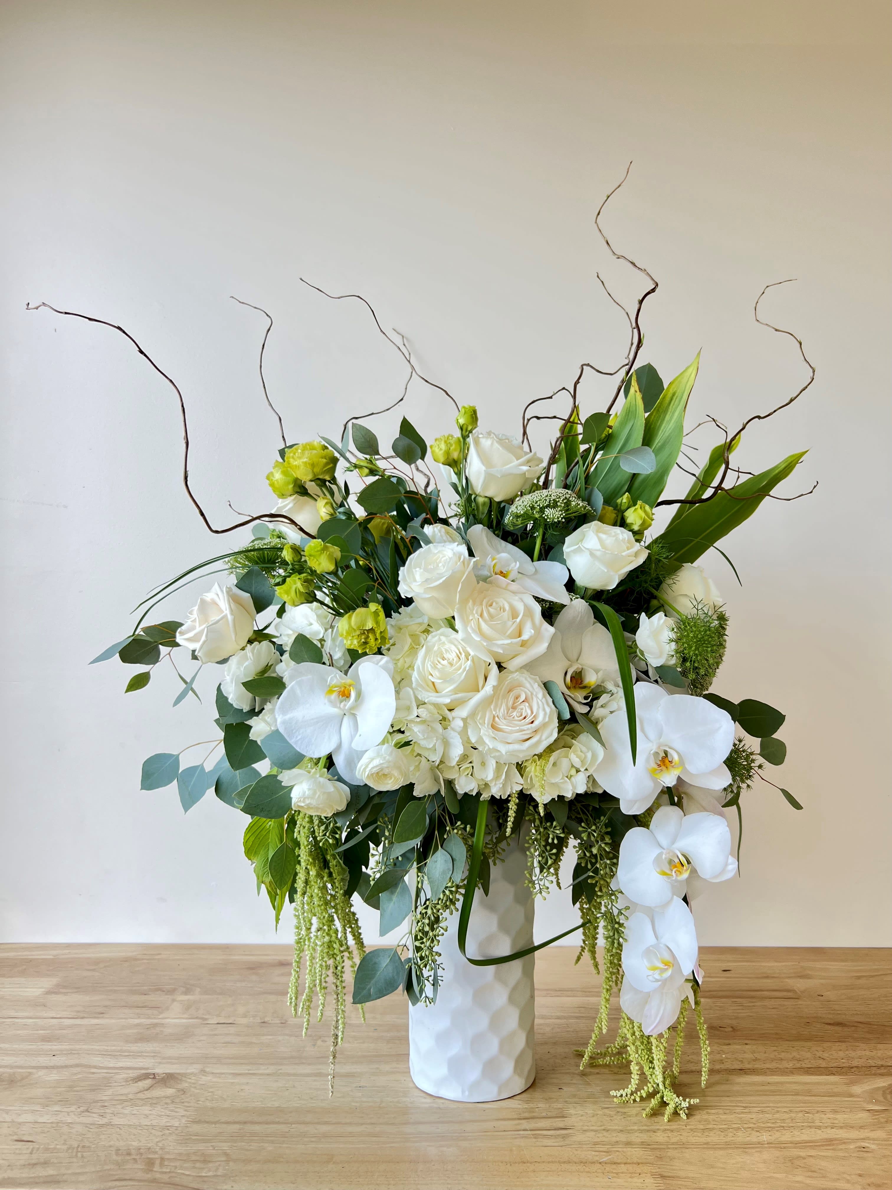 Blanca Sensacion - Beautiful one-sided arrangement with a mixture of roses, orchids, hydrangeas, greenery, lisianthus, and more. 
