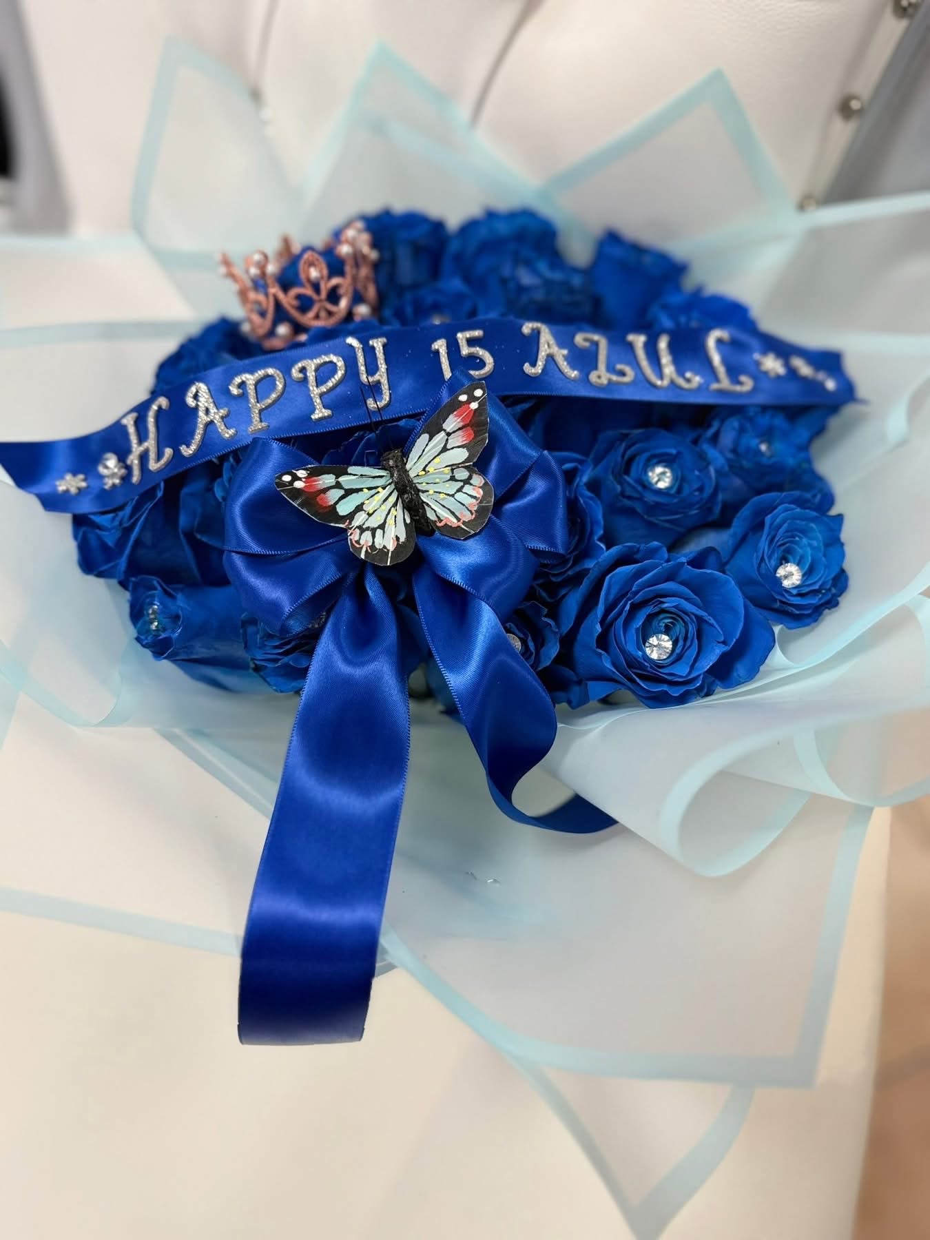 Ramo buchon blue - 24 blue Rosa’s including butterfly crown and little diamonds with light blue paper and make you own message for you banner