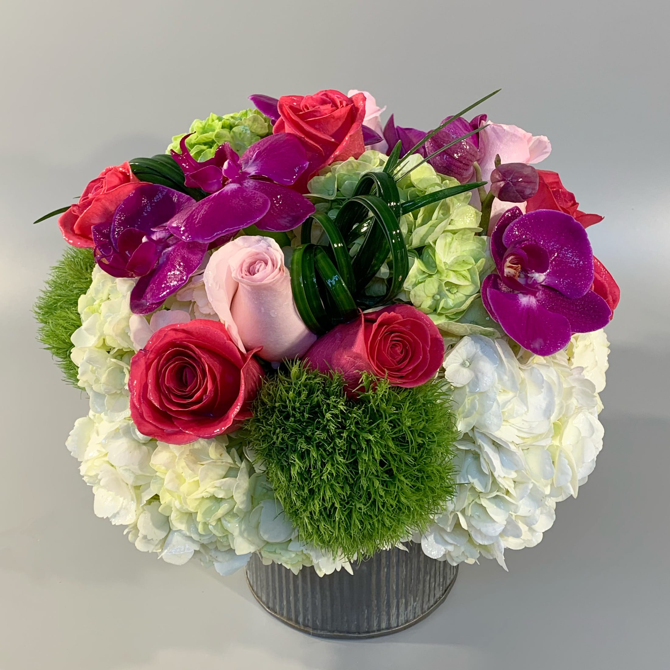 PARIS - A combination of seasonal textures of roses, dianthus, and designed in a leaf-lined glass vessel. *Flower varieties may be substituted seasonally.