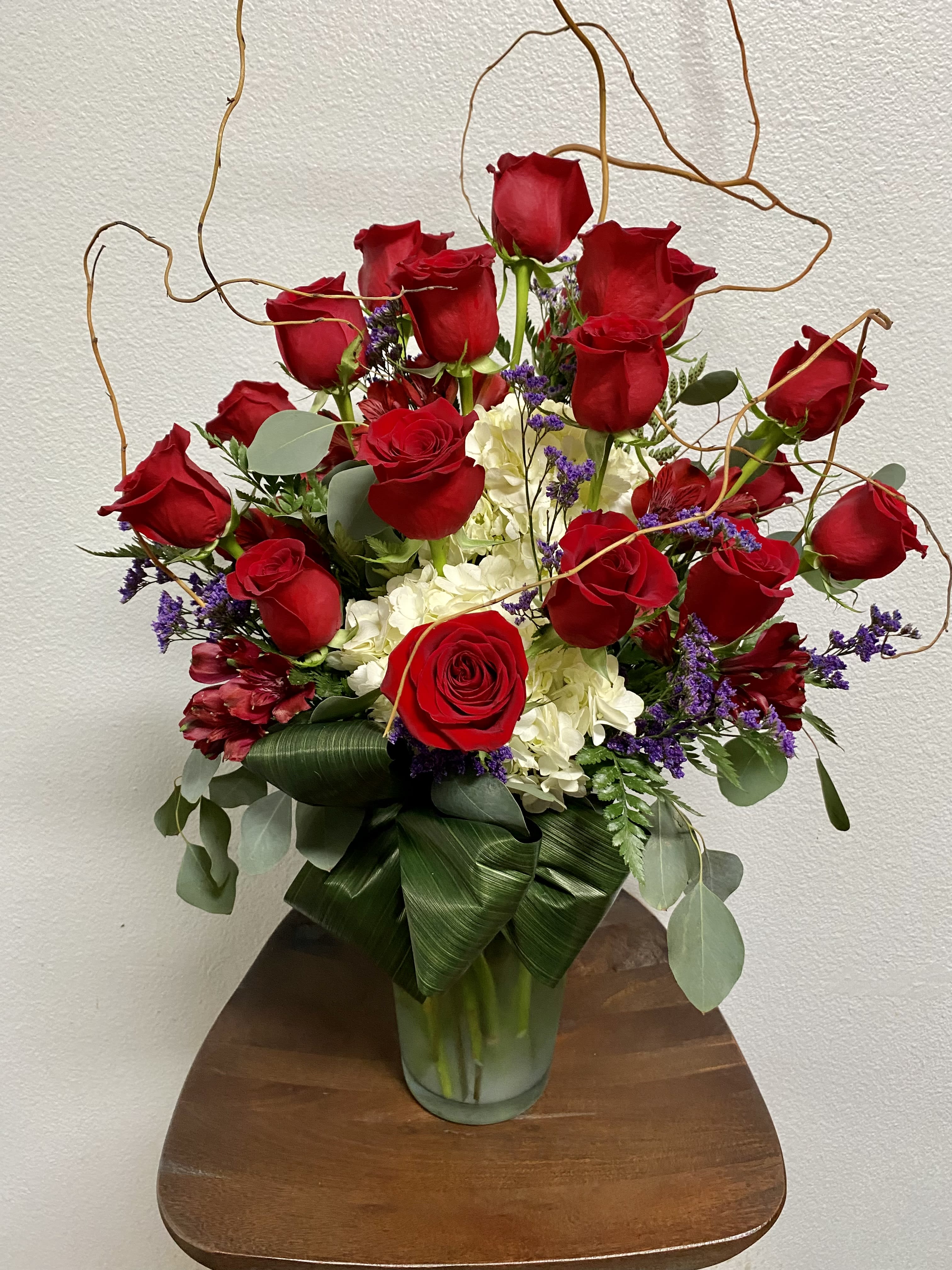 Grande Beauty - Pictures don't do justice to this massive arrangement! It is sure to wow anyone. 18 red roses accompanied by lush mixed flowers are heart stopping!  18 long stem red roses, with white hydrangea, alstroemeria and filler in tall glass vase.