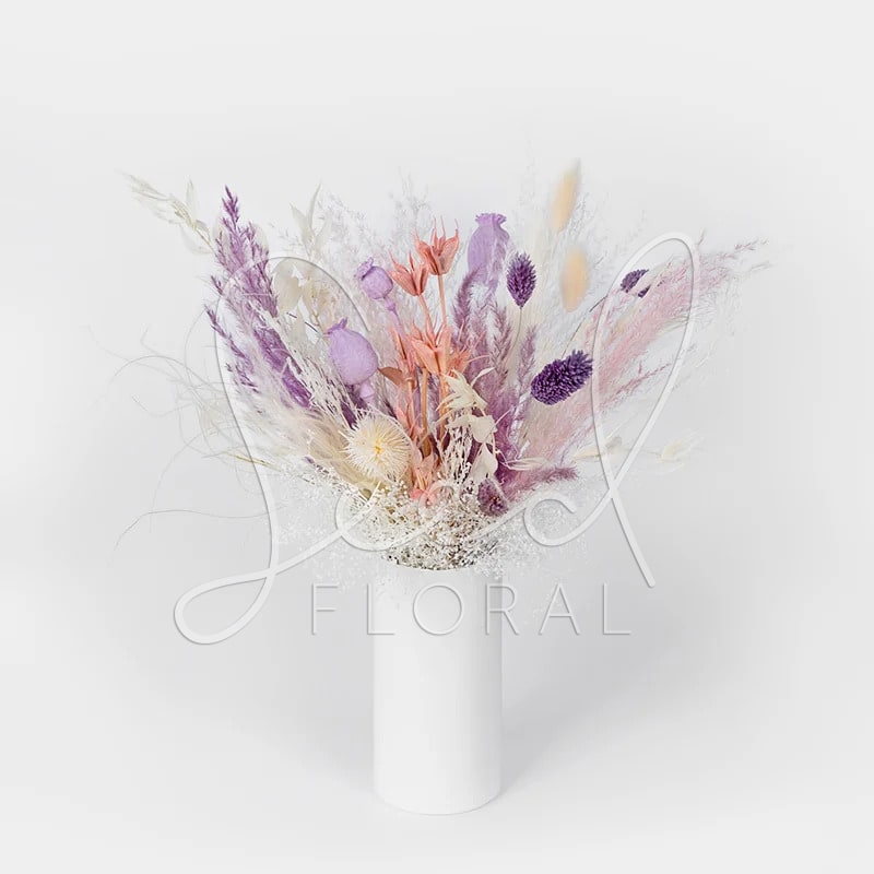 Forever Pastel Arrangement  - Inspiring arrangement of florals to last all year long. Featuring: Premium preserved florals in lavender, blush, cream and white.  Vase: White Gloss Porcelain STANDARD SIZE/ Height Vase: 5.5"H x 2.75"W  Full Arrangement: 14" H x 14" W PREMIUM SIZE/ Height Vase: 8"H x 3.75"W  Full Arrangement: 18" H x 18" W  How to care for your preserved florals: *Each bouquet is handmade with the same components however each of them are arranged slightly different. The colors and size may vary from one to another since they are dried and preserved flowers  *Avoid direct sunlight. Light may cause color variation and fading. *Drink-free floristry! No water is required. *Keep in a cool, dry spot in the home as humidity may cause discoloration. *Do not expose your preserved blooms directly to air conditioning or heating vents. *And most importantly, make sure to take pleasure in your new everlasting bouquet!