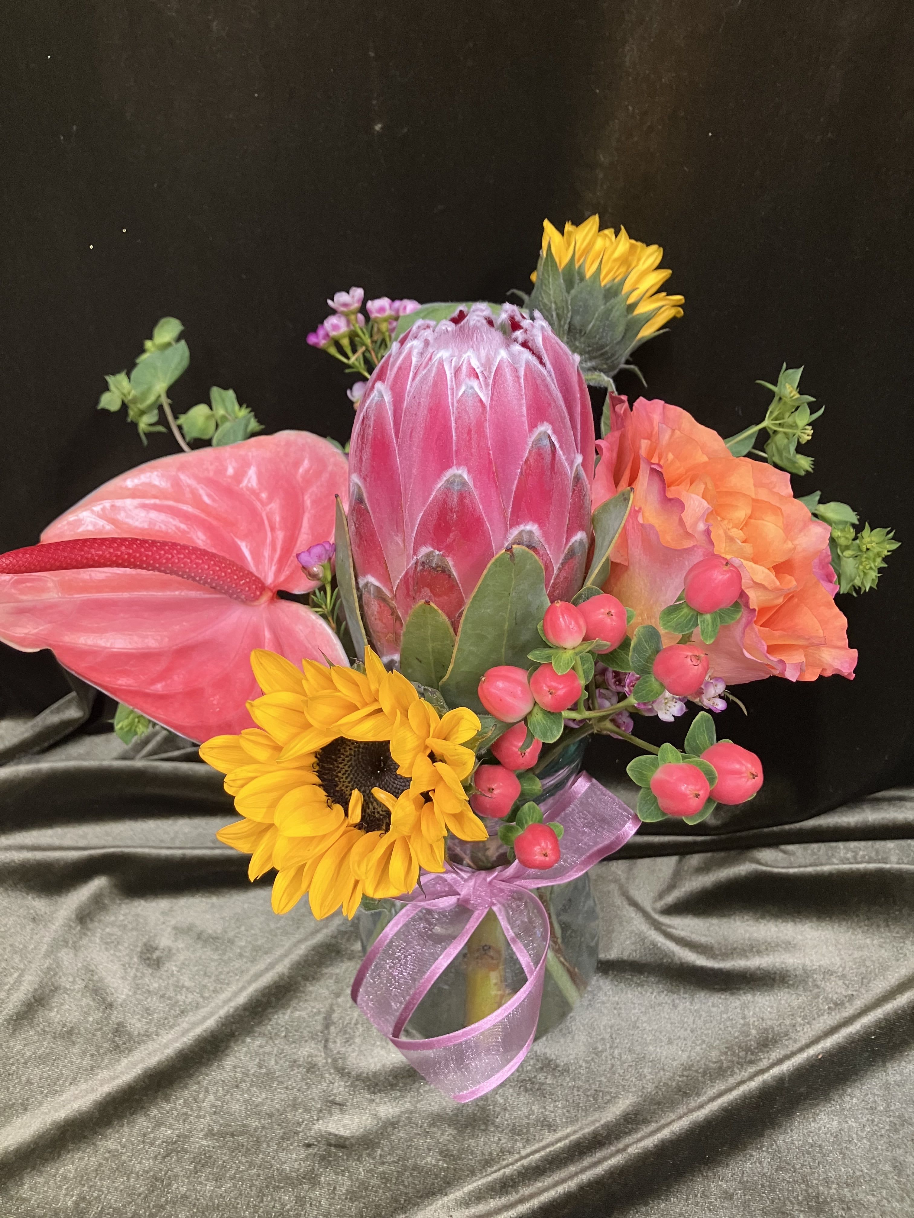 Short but Sweet  - Fun and unique fresh flower arrangement that includes a pink mink protea, free spirit garden rose, anthurium and sunflowers