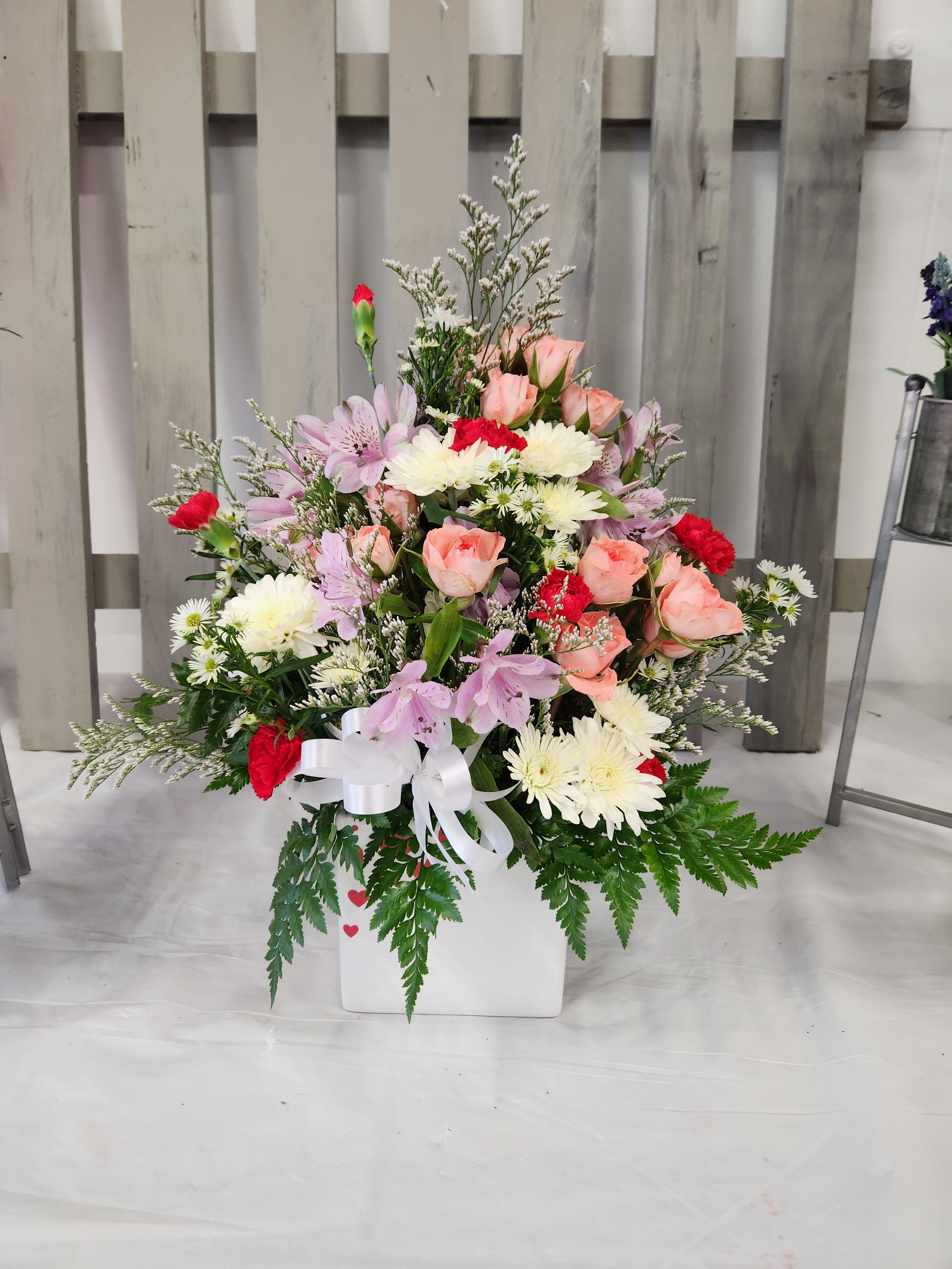 Red Heart Bouquet  - Share your heart's true feelings with this delightful red, white, pink, and lavender bouquet. Placed in a white ceramic container decorated with hearts. A lovely choice on Valentine's Day, they'll always remember.  
