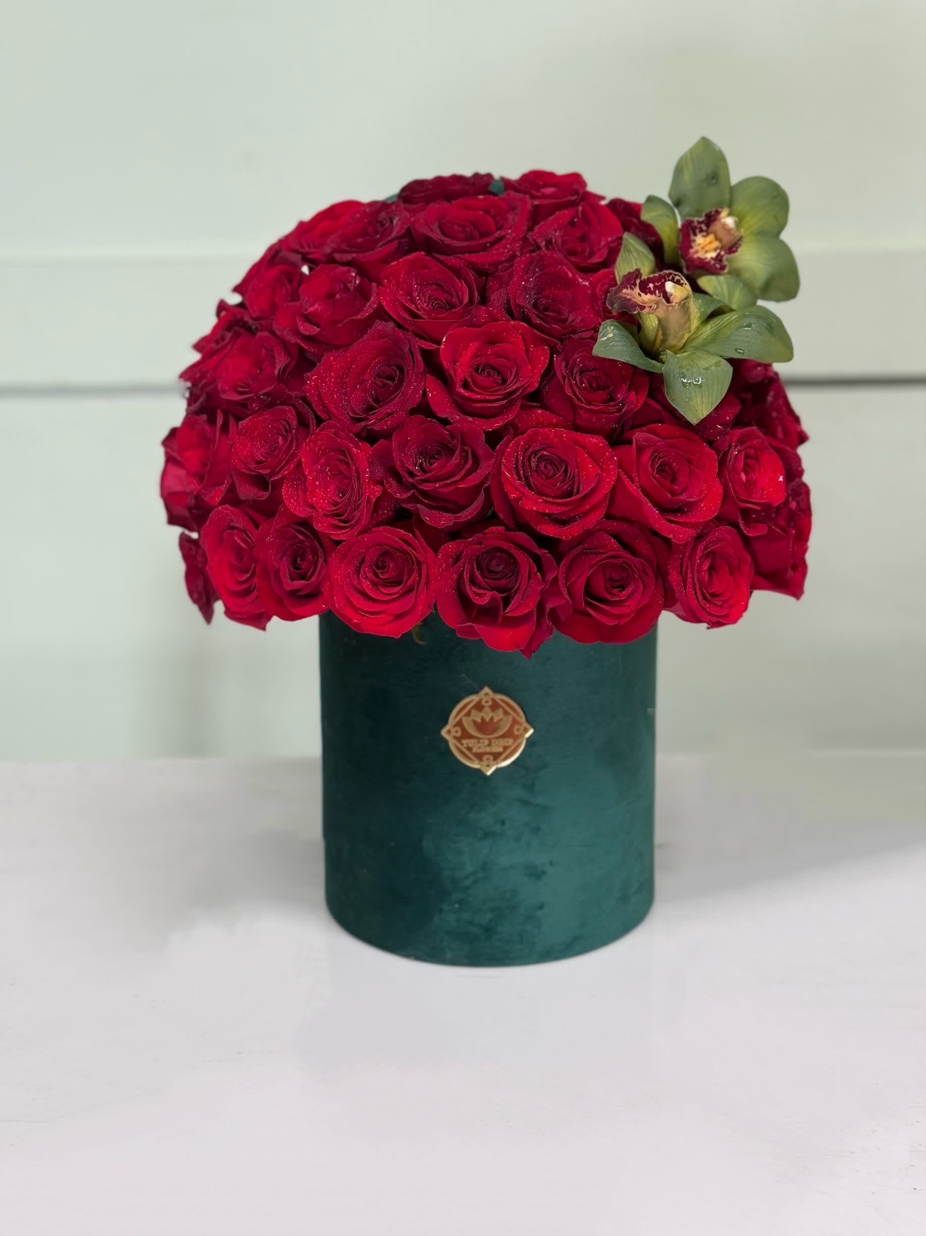 Red and green  - Red roses with Orchids in a velvet box .  Standard 50 red roses.  Deluxe 75 red roses. 
