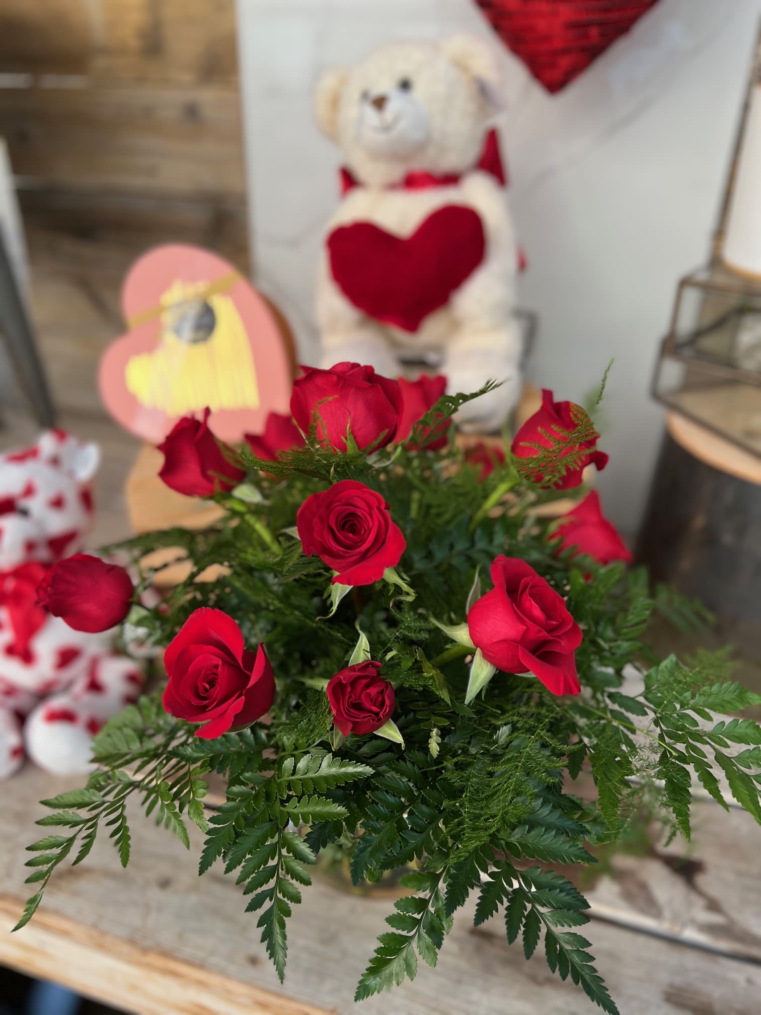 Red - A traditional vase of a dozen red roses with greens. 