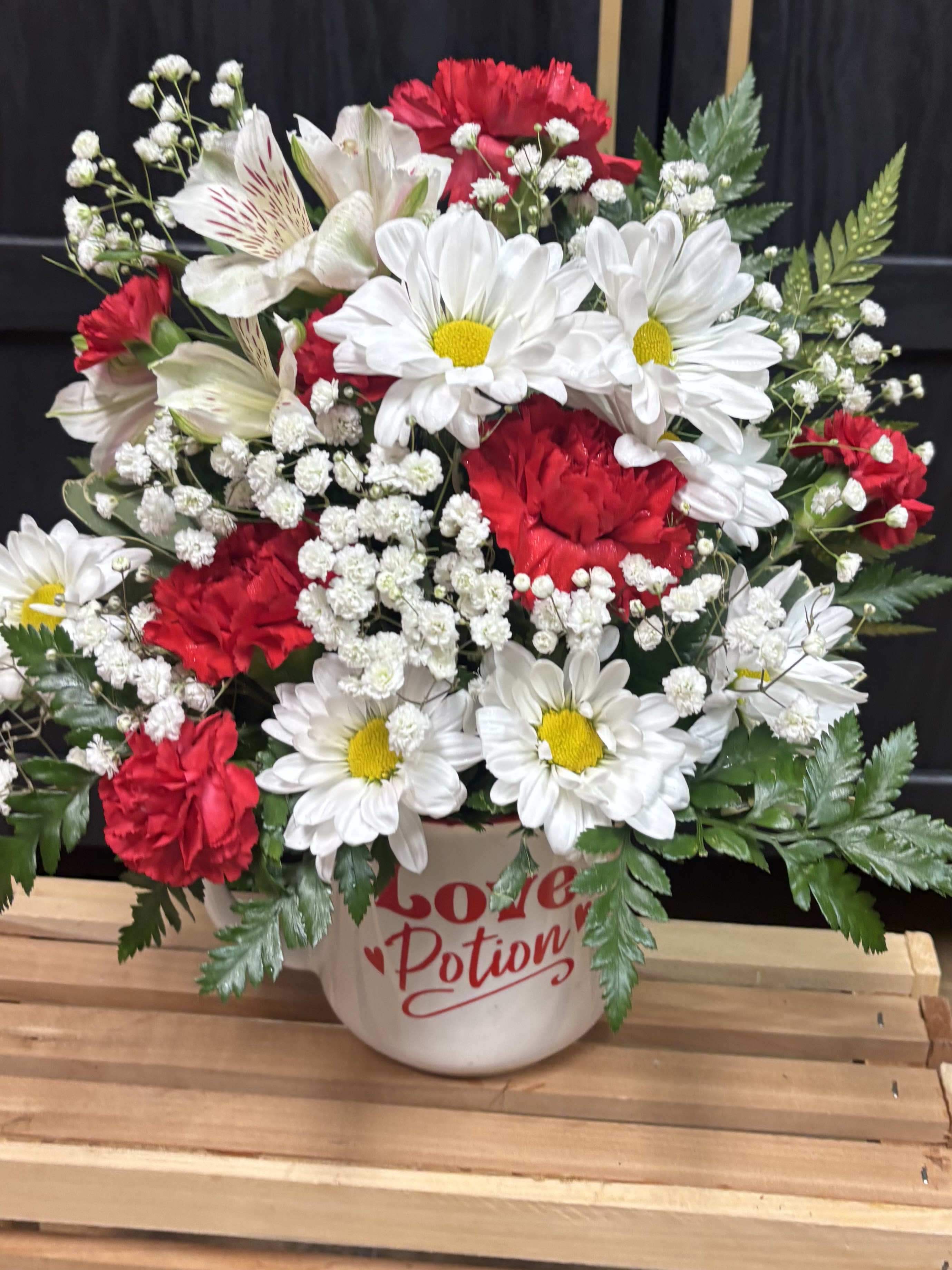 Potion of Love Arrangement - A sweet and cheerful Valentine’s mix of red carnations, white daisies, baby’s breath, and lush greens—designed in an adorable “Love Potion” mug. Perfect for gifting, decorating, or sending a little love just because! ️