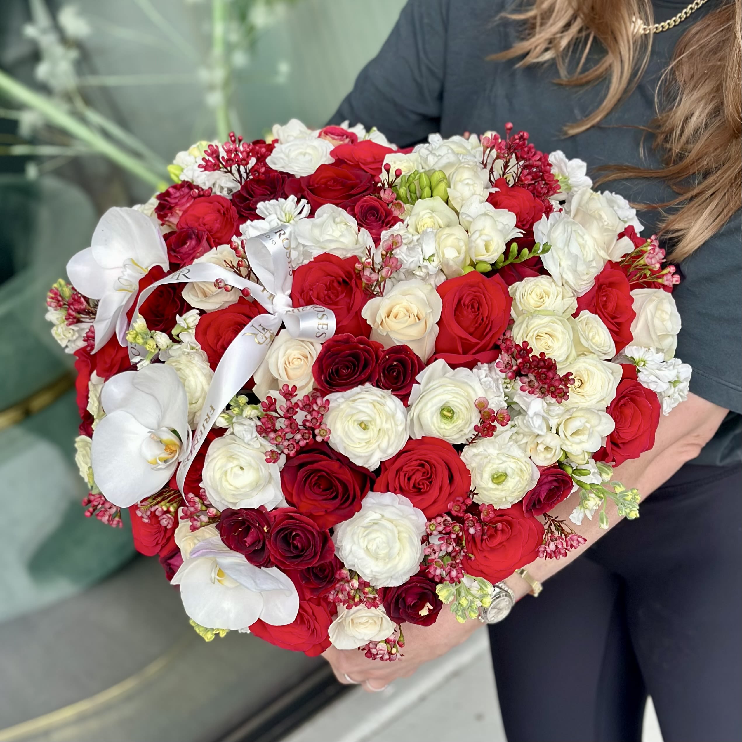 Barbara - A romantic heart-shaped box featuring a luxurious blend of red and white roses, delicate ranunculus, and elegant orchids. This arrangement symbolizes love, harmony, and refined beauty, making it a perfect gift for meaningful moments and special occasions. Designed to impress and crafted with attention to every detail.  *** Flowers may vary depending on seasonal availability.
