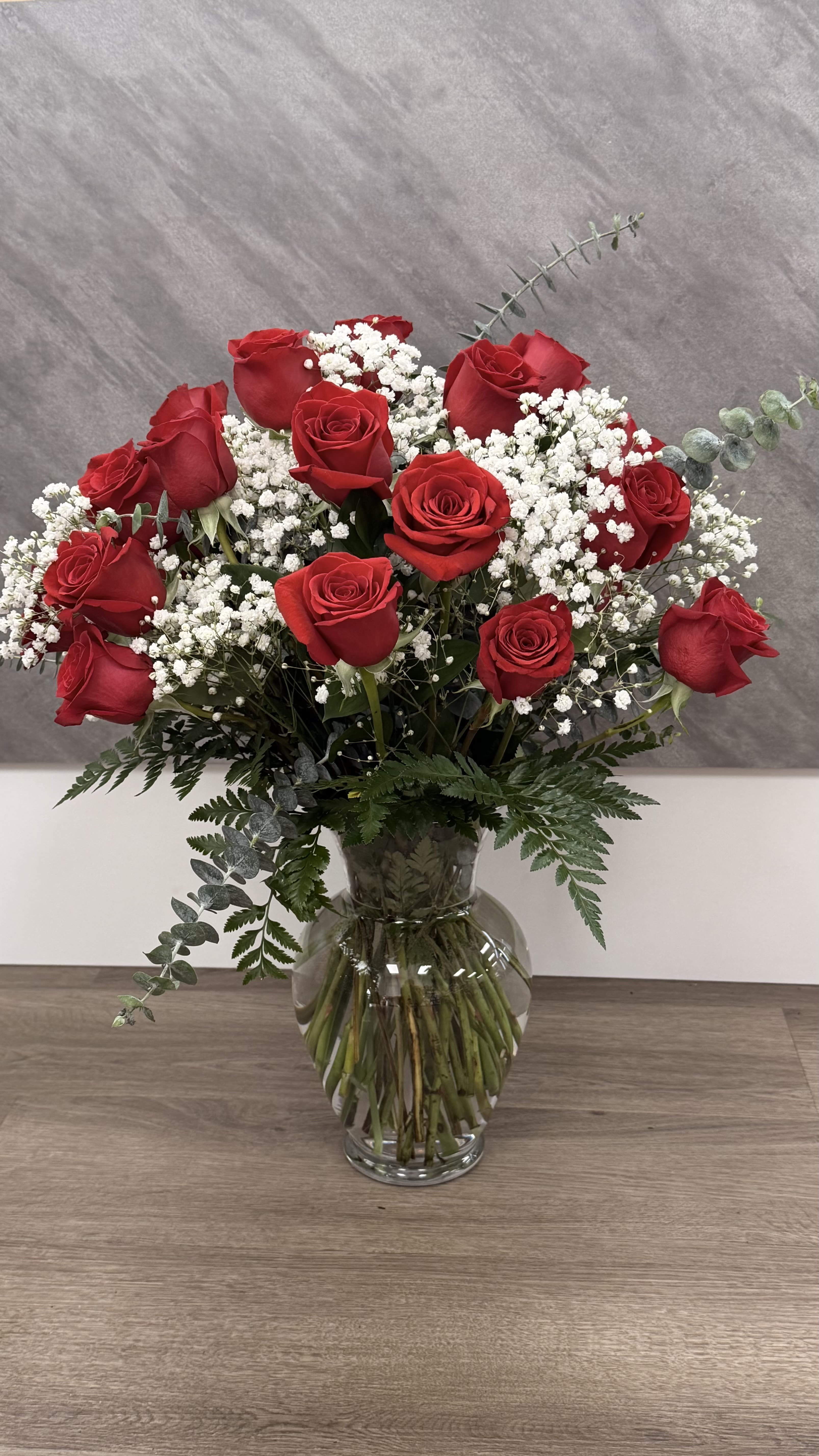 Red Rose Elegance - Classic red roses paired with delicate baby’s breath, beautifully arranged in a clear glass vase. A timeless expression of love and romance.